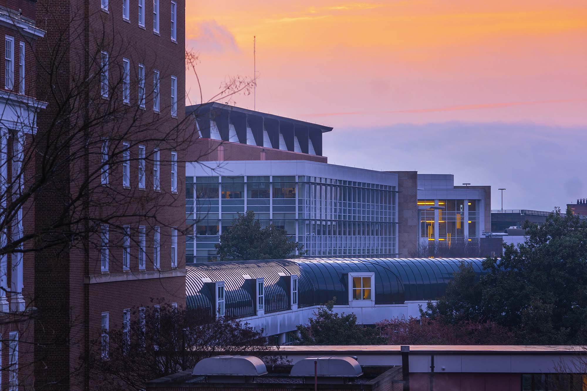 View of the hospital against a yellow, orange, blue, and purple sunset