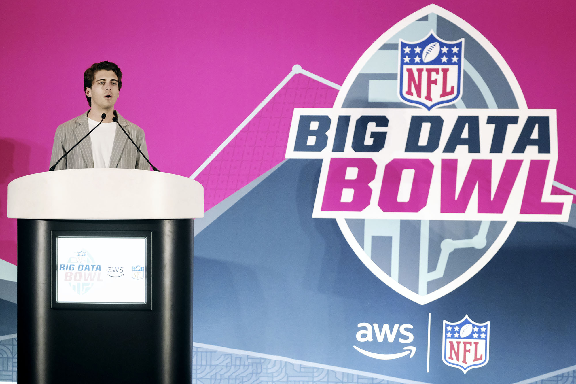 Alex Stern standing at a podium speaking at the Big Data Bowl