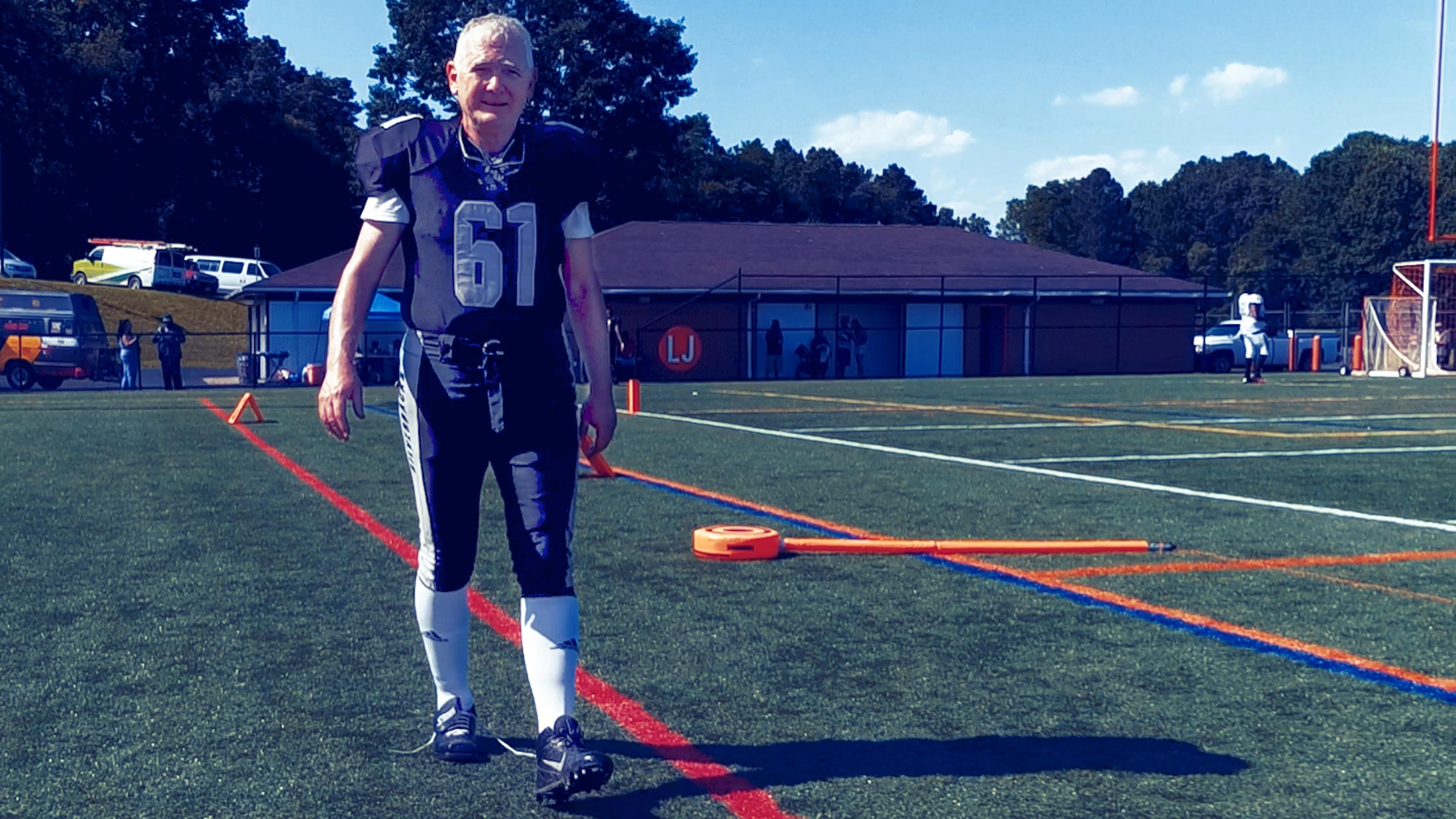 Professor Allen Lynch walking in a football uniform on the field