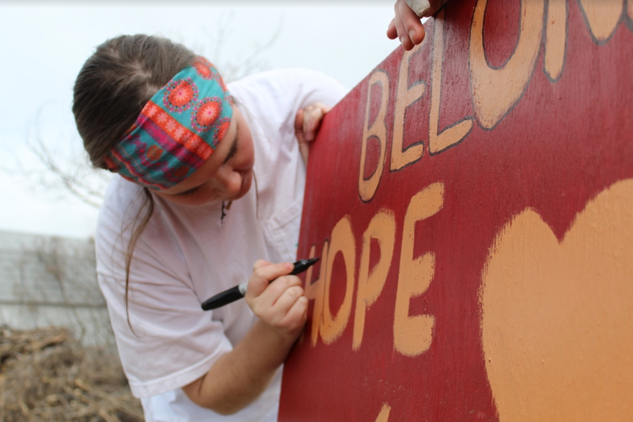 Kate Price paints a sign