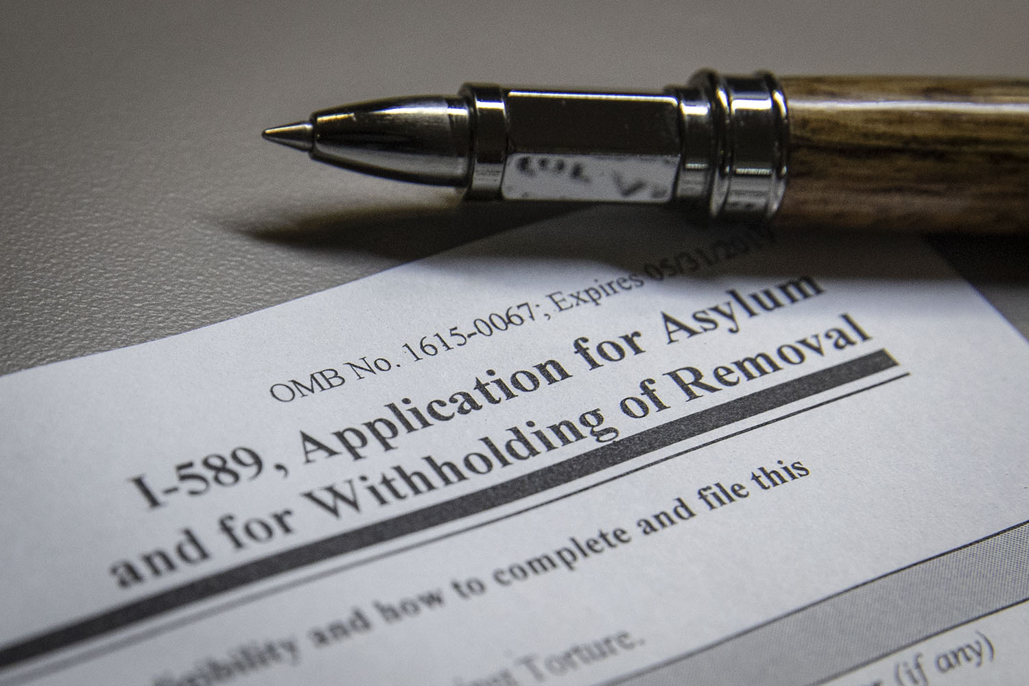 up close view of the form and pen. The form reads: I-589, Application for Asylum and for Withholding of Removal