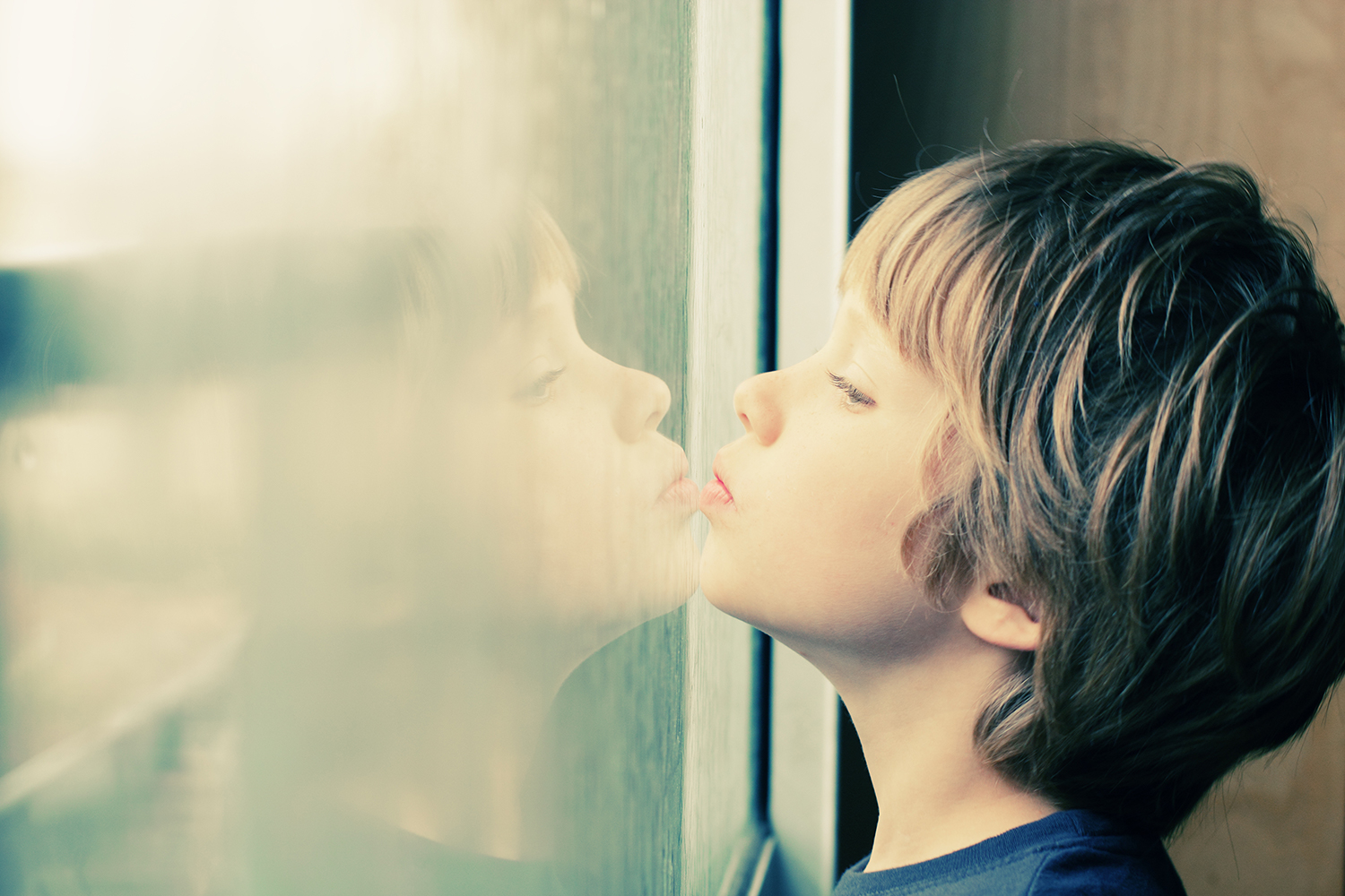 Boy with his chin on a window