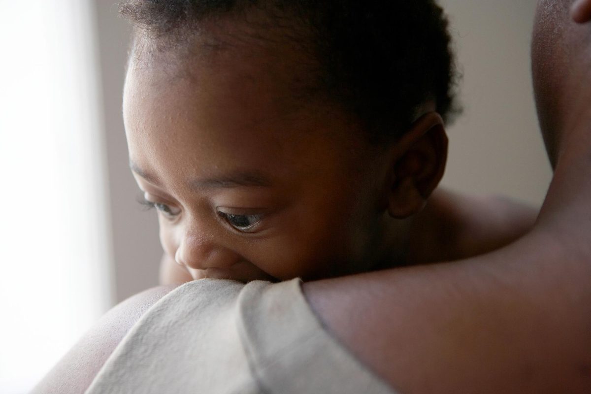 Baby leaning on the shoulder of a mom