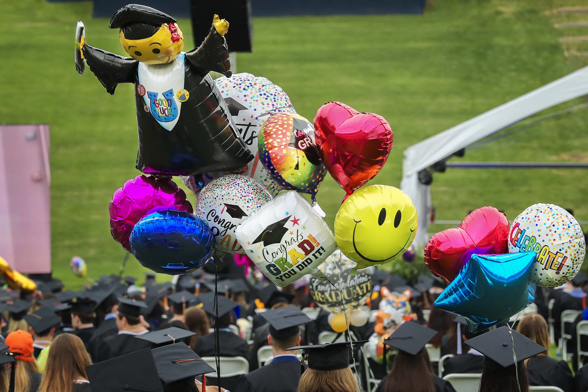 Graduates walking into final exercises carrying balloons