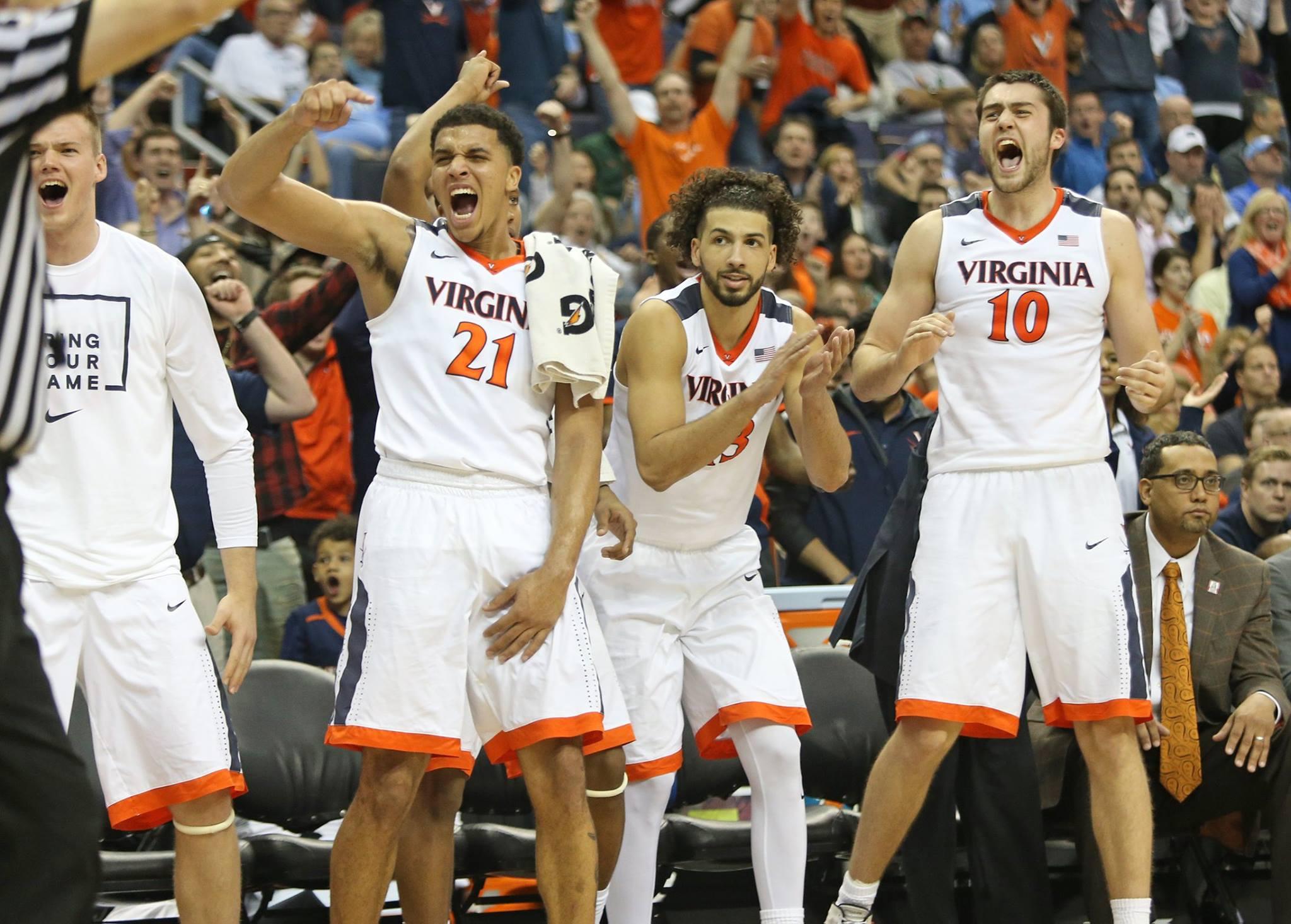 UVA Men's basketball players cheering on their teammates from court side