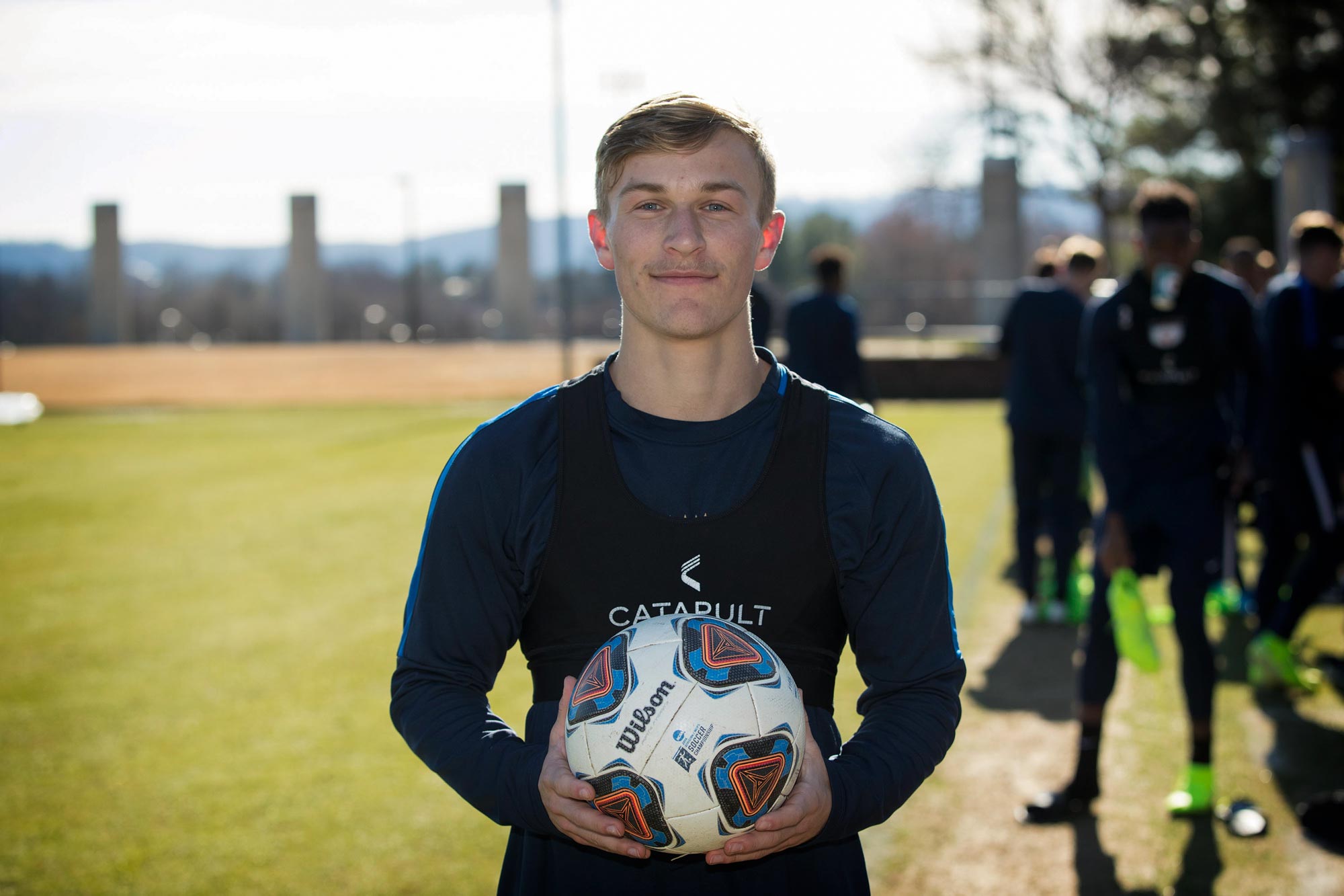 Beau Bradley holding a soccer ball and facing the camera
