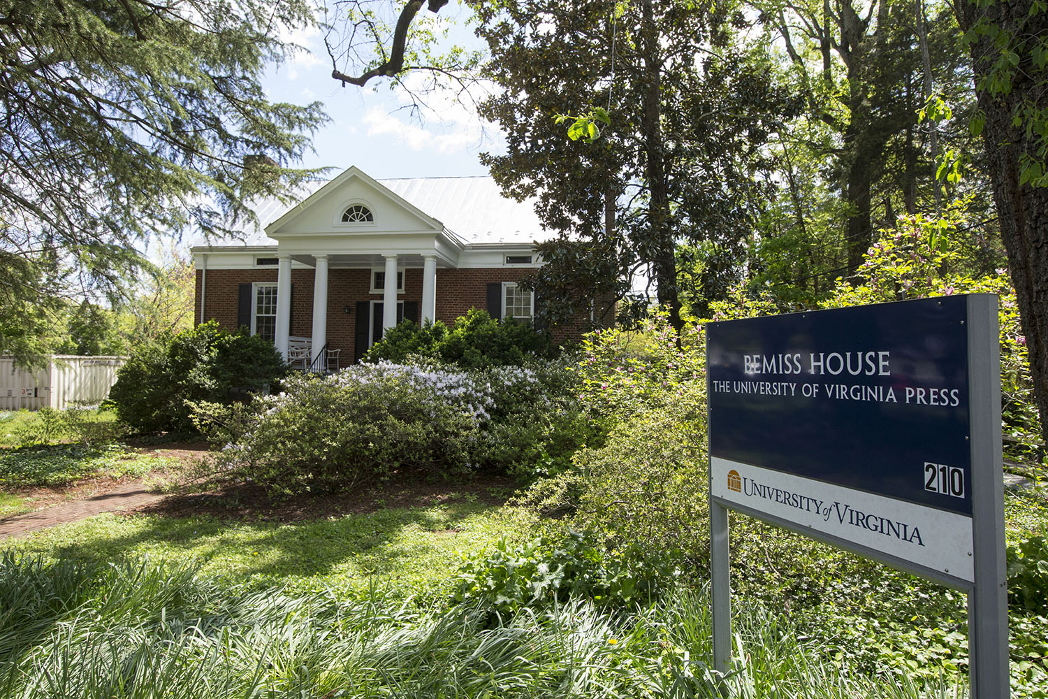 UVA Miss House sign and outside of the building which is surrounded by green plants