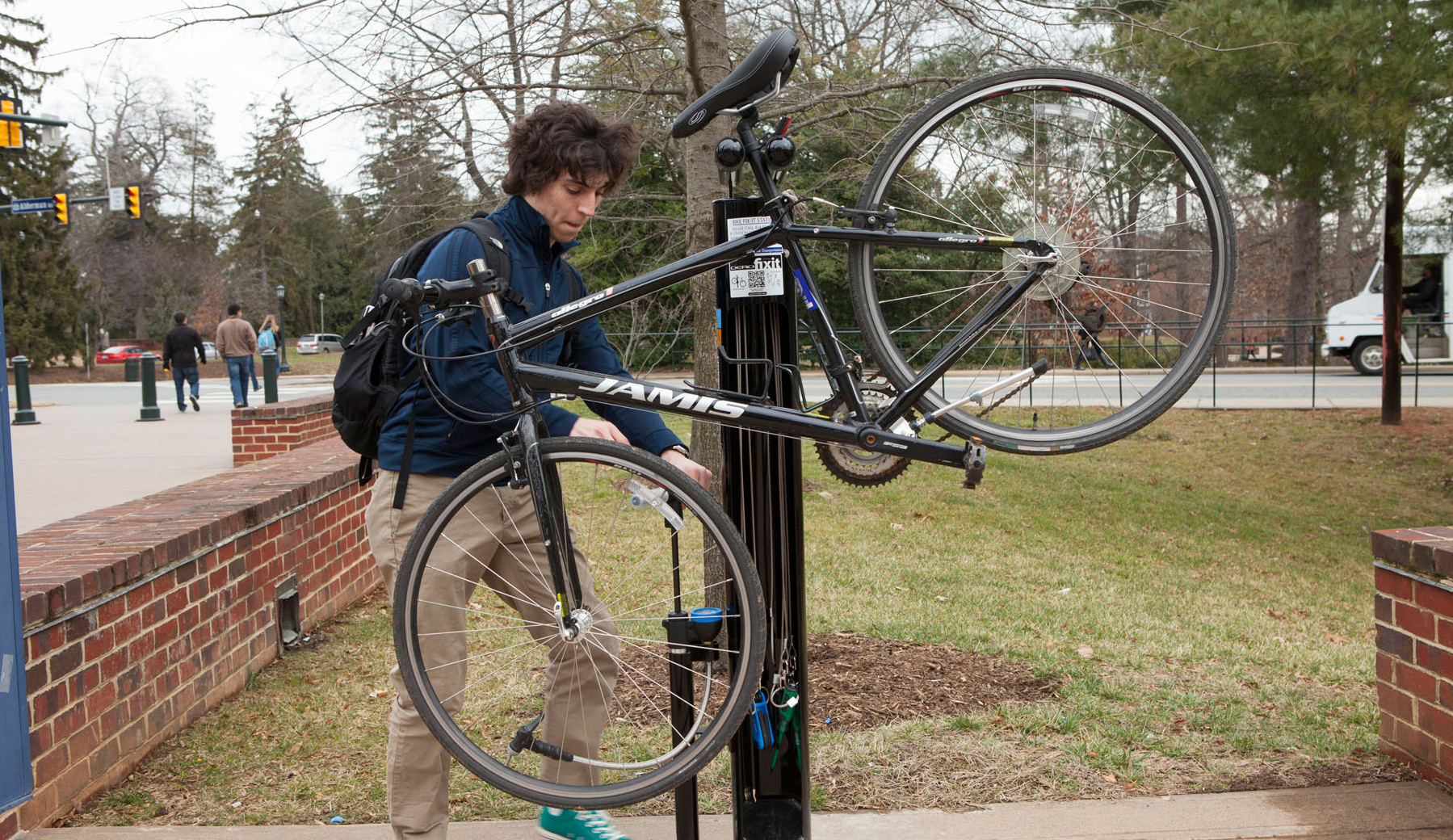 Man putting a bike in a bike fix-it station
