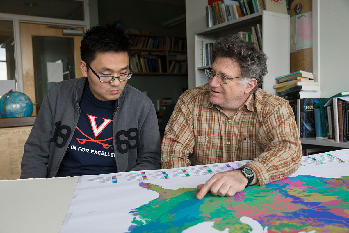 Manuel Lerdau, right, and Ph.D. candidate Bin Wang look at a map together on a table