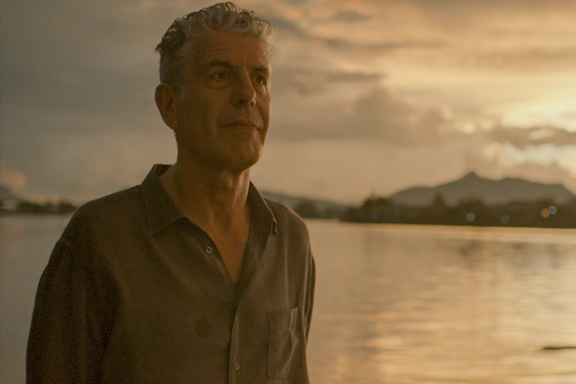 Anthony Bourdain standing next to the water