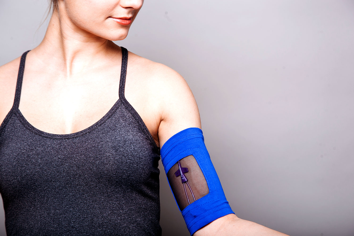 An antimicrobial PICC line cover on woman's bicep with a clear window to see the iv line