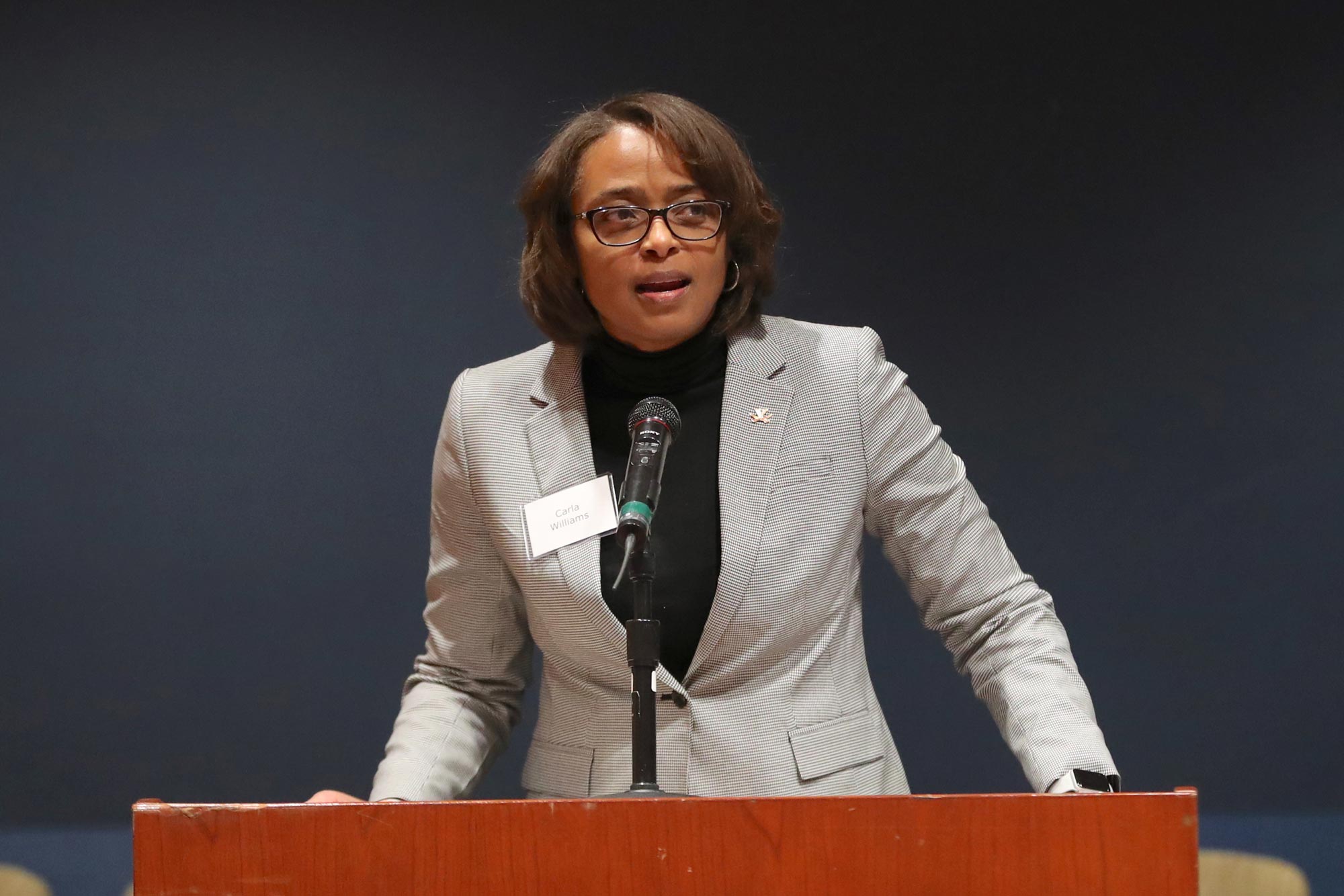 Carla Williams standing at a podium speaking to a crowd