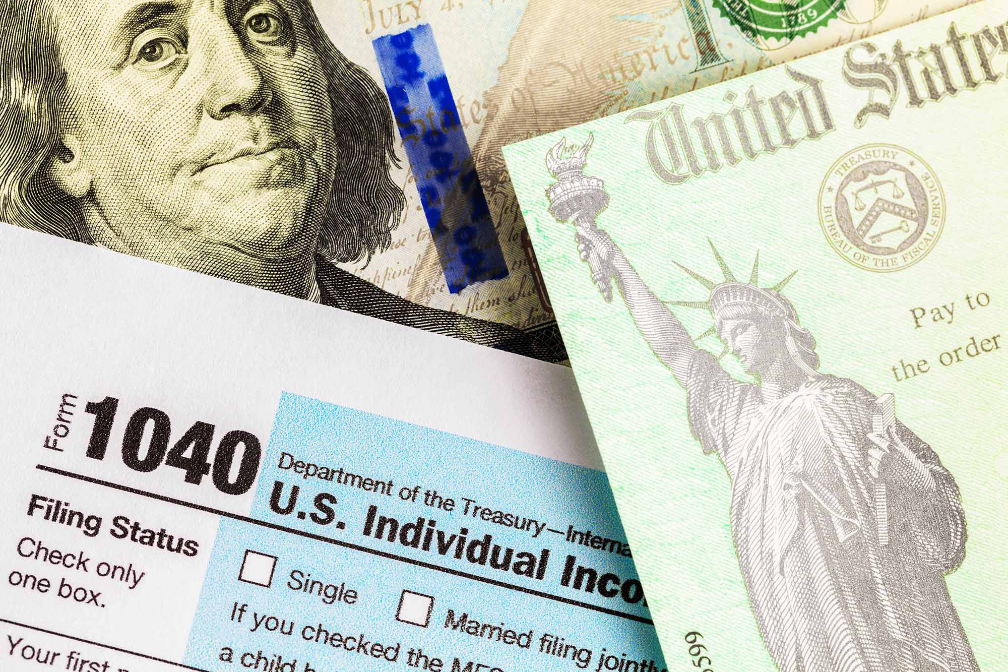 US 1040 tax return, tax return check, and a 100 dollar bill