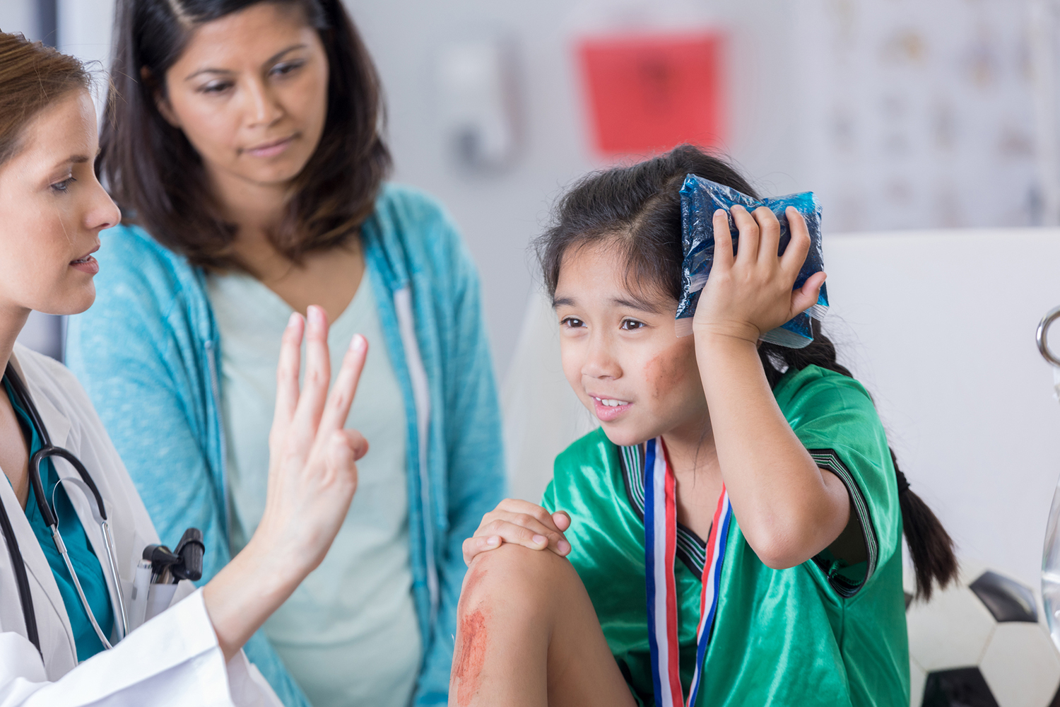 Kid holding ice on their head looking at a medical professional holding up 3 fingers