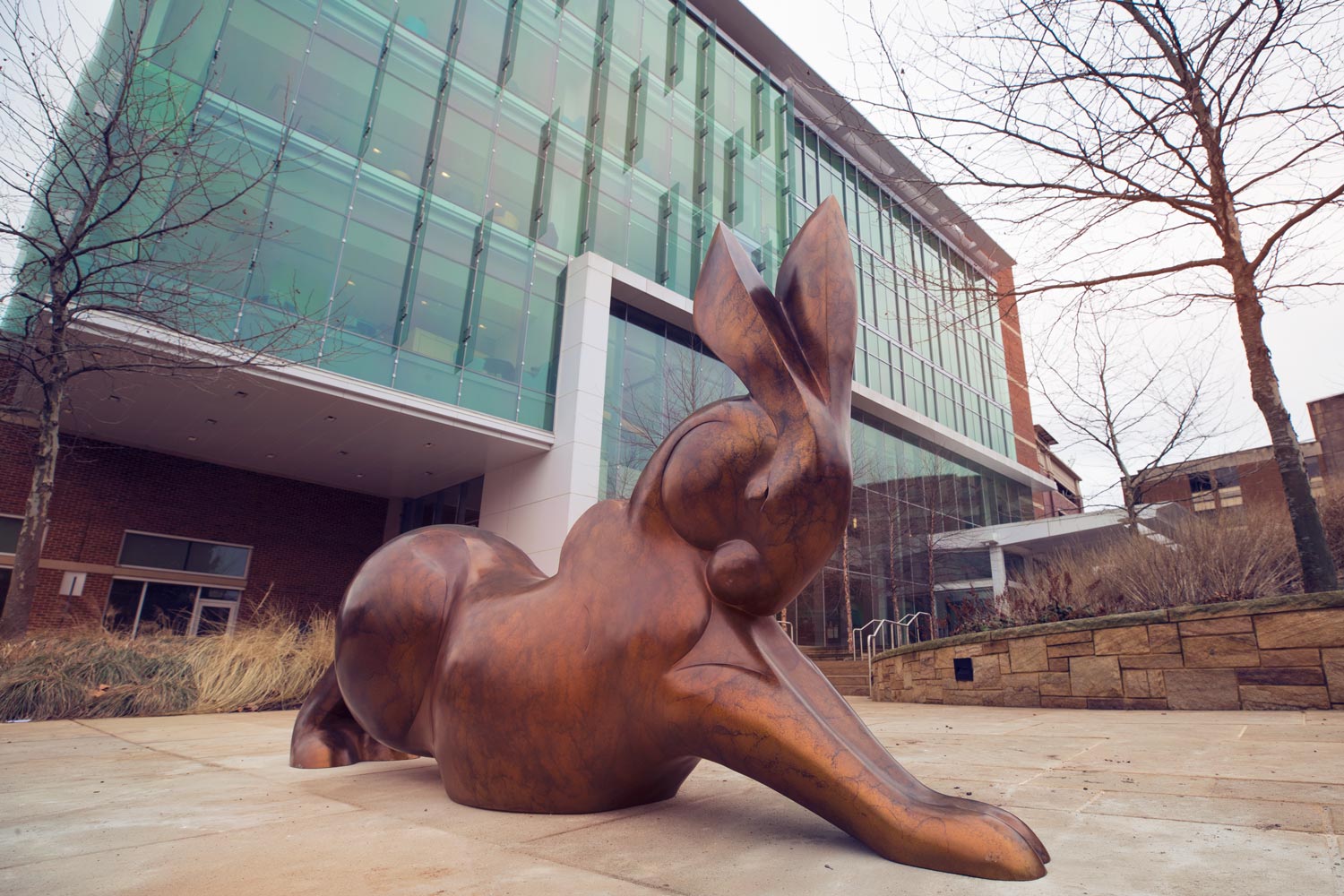 A big bronze bunny statue in front of a building
