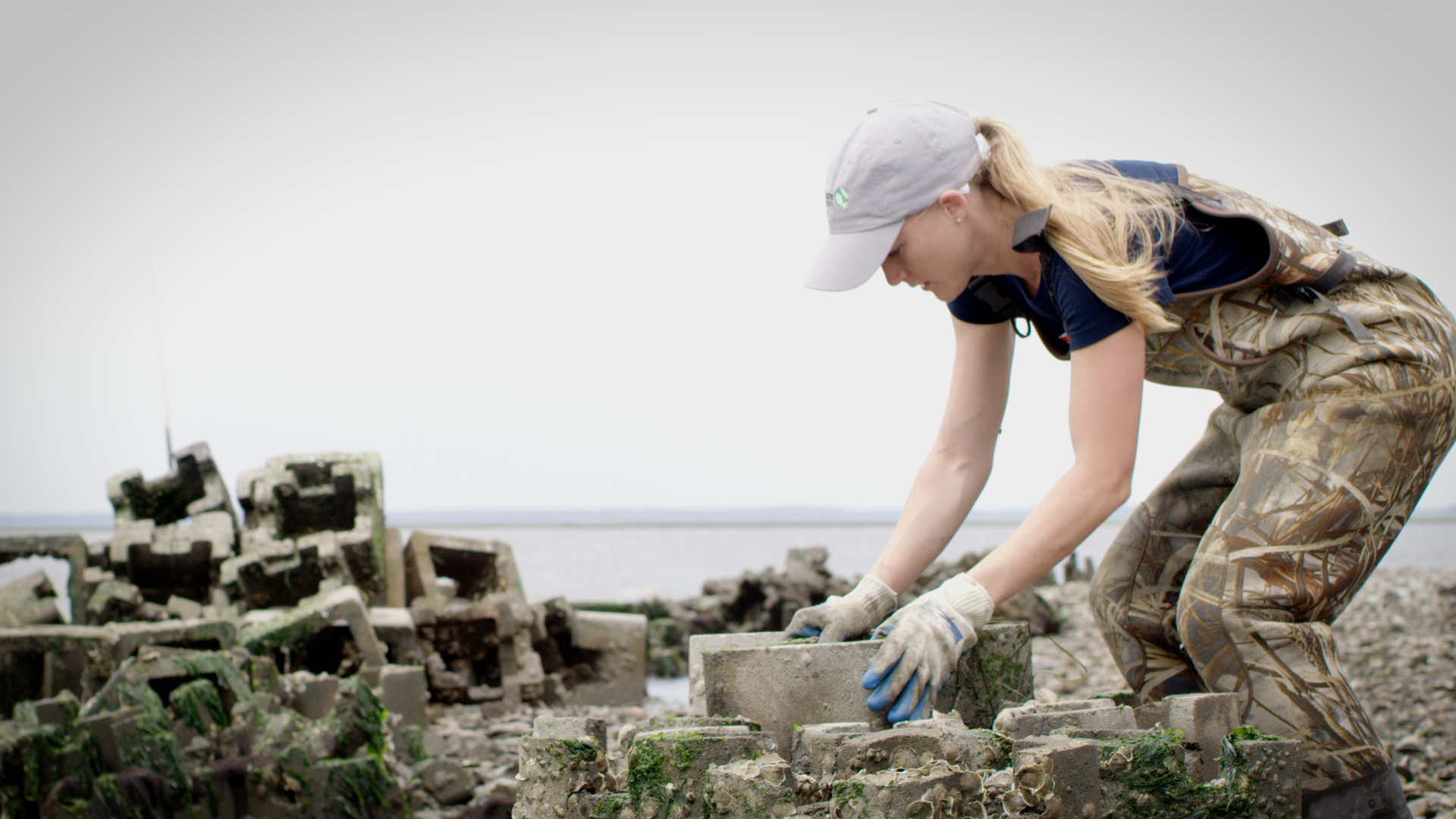 Woman working to move cinderblock pieces
