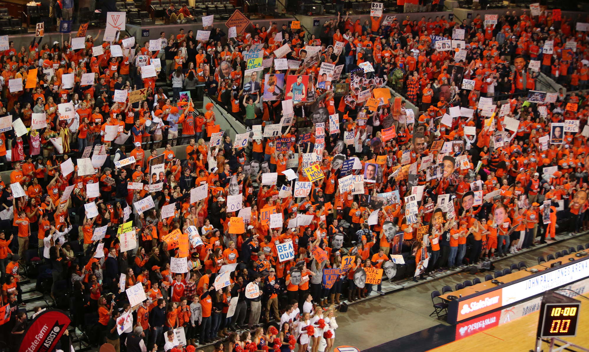 UVA Fans dressed in orange holding signs and cheering during college Gameday at a basketball game
