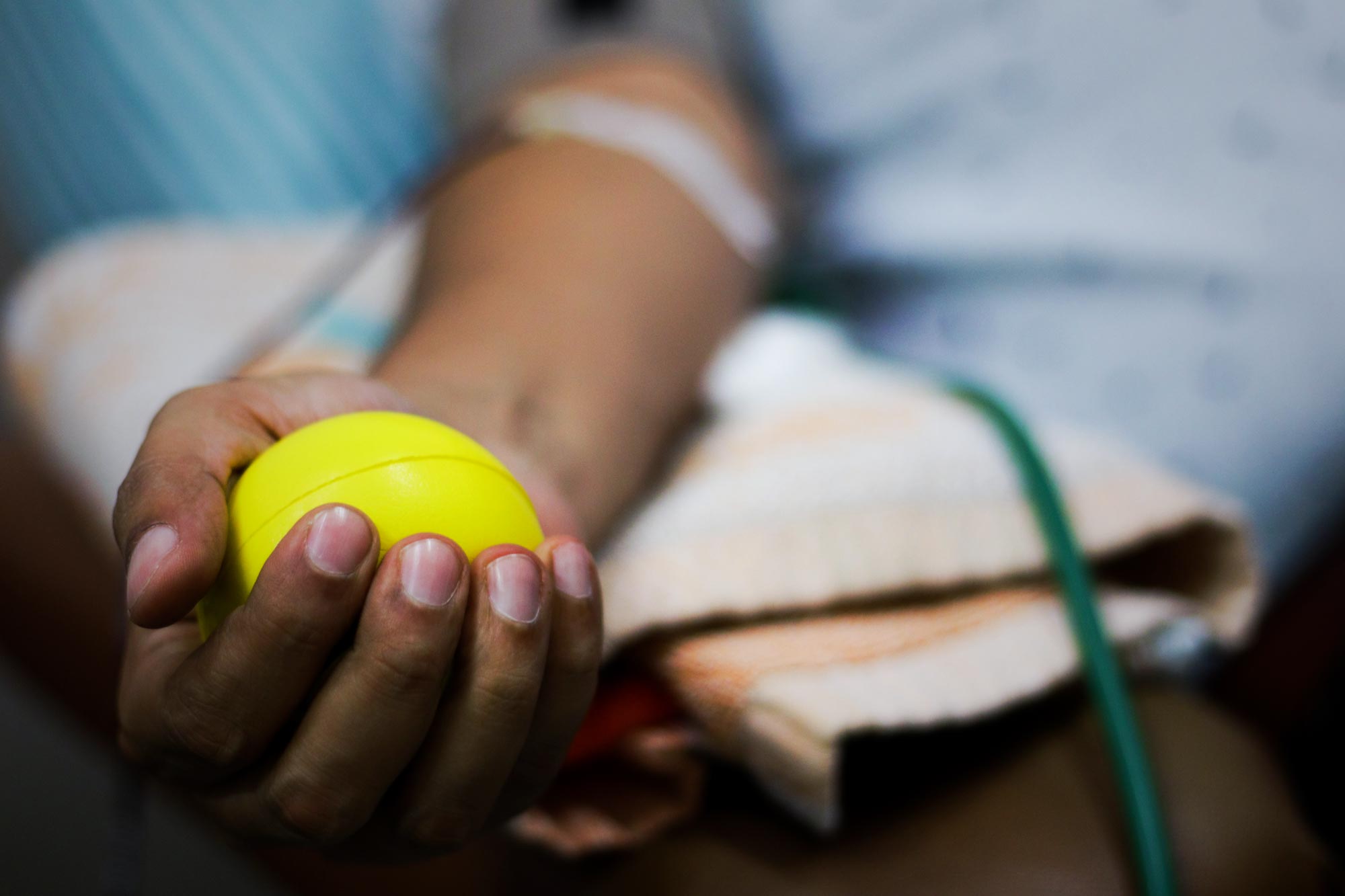 up close of patients hand clinching a stress ball