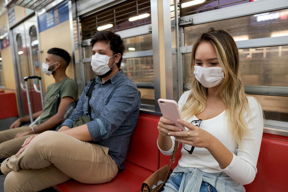 People sitting on a subway with masks