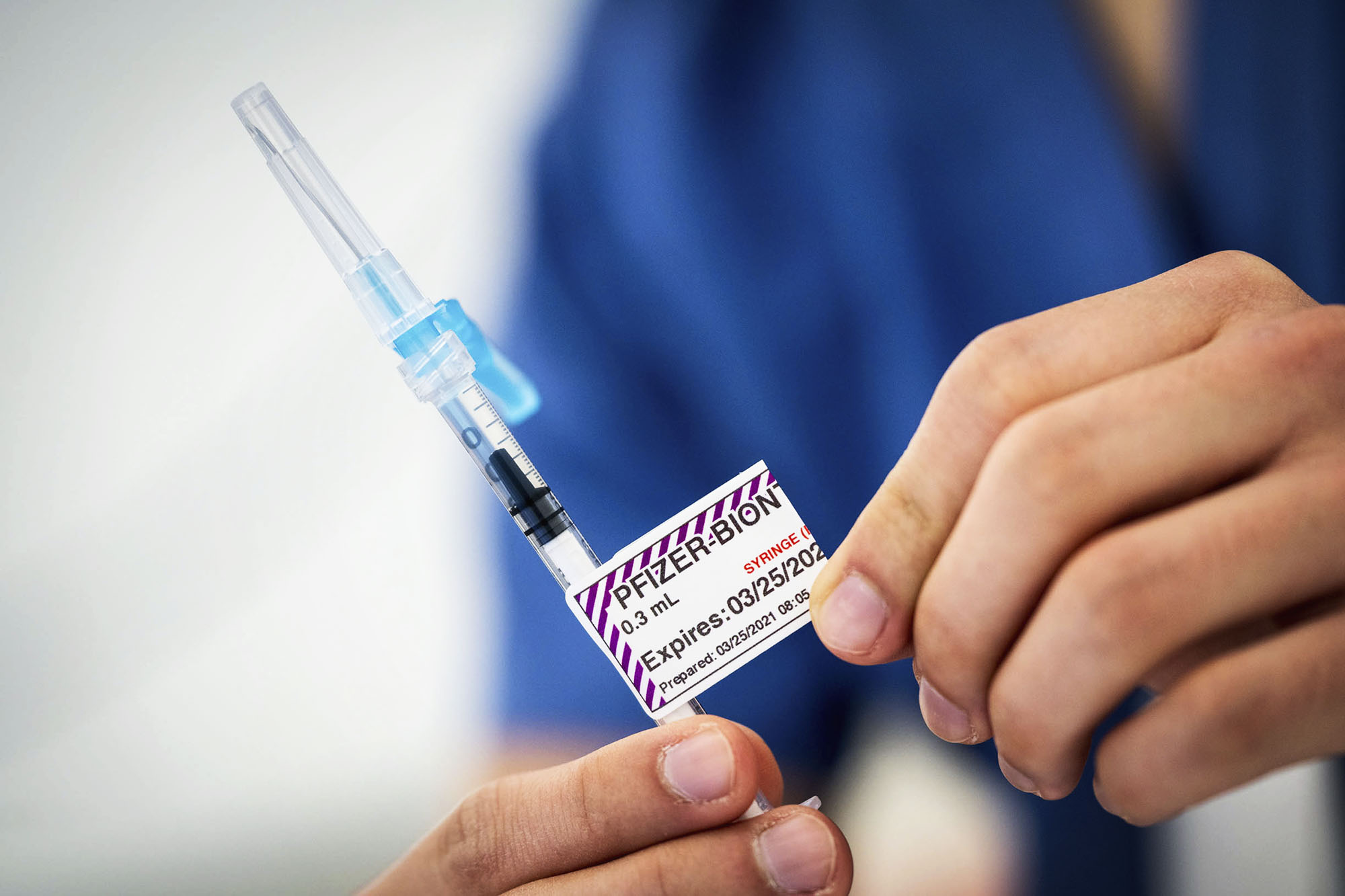 healthcare professional holding pre-filled Pfizer vaccine syringe