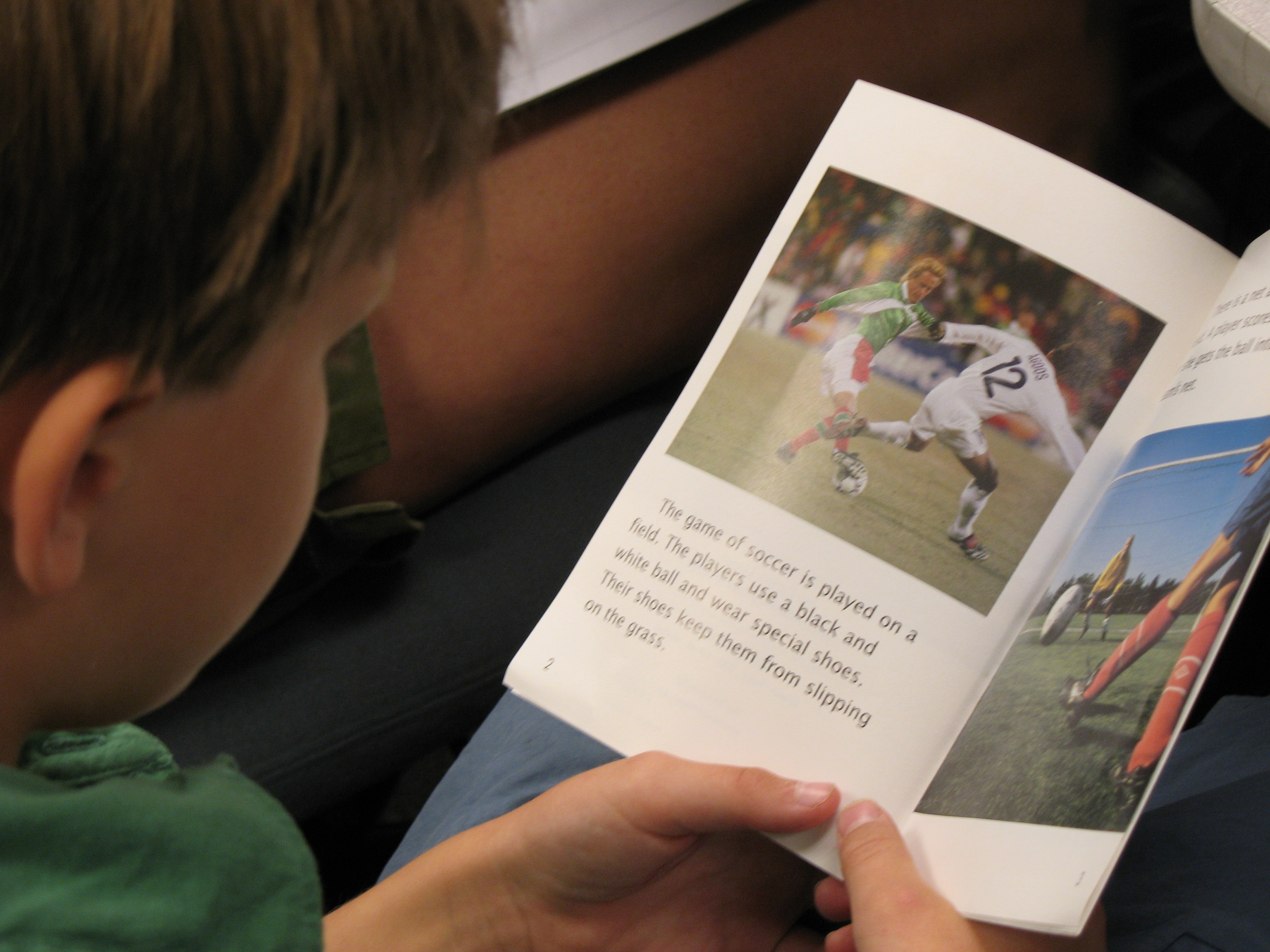 Child reading a book about soccer