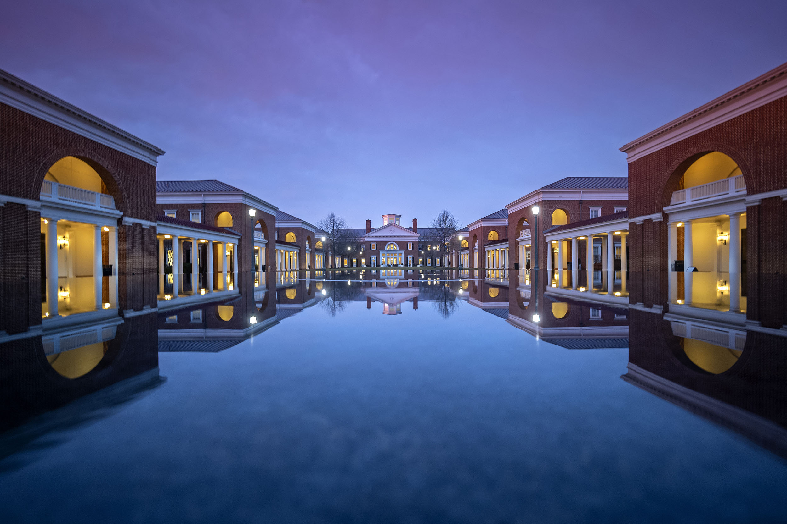 Reflection pond at Darden at dusk with the lights and building reflecting off of the water