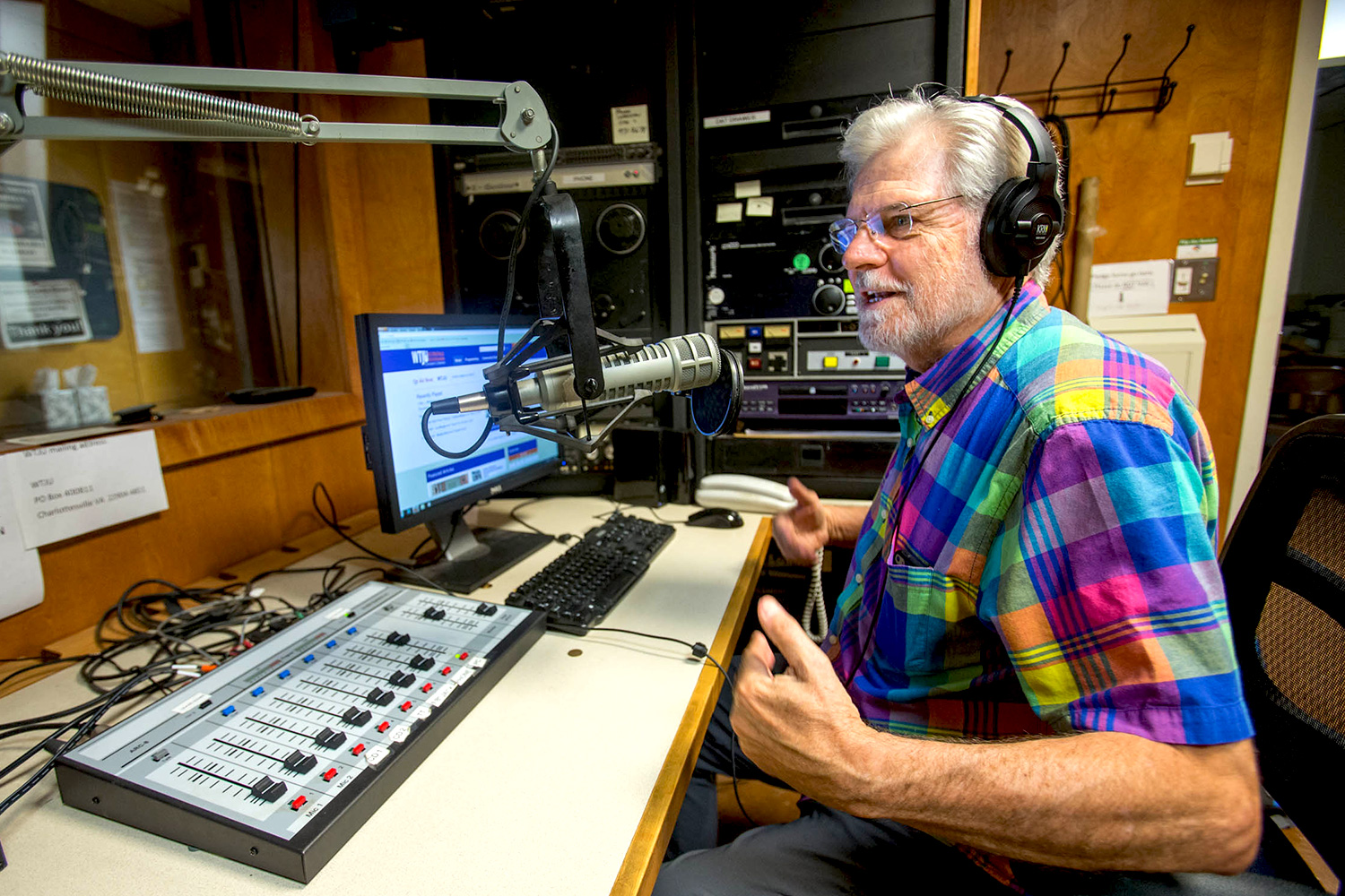 Dave Rodgers recording a radio show in front of a microphone with headphones on