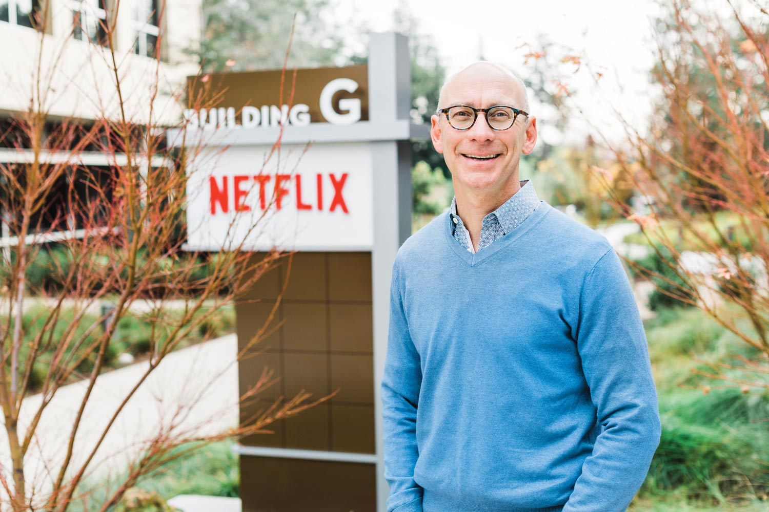 David Hyman stands in front of an outdoor Netflix sign