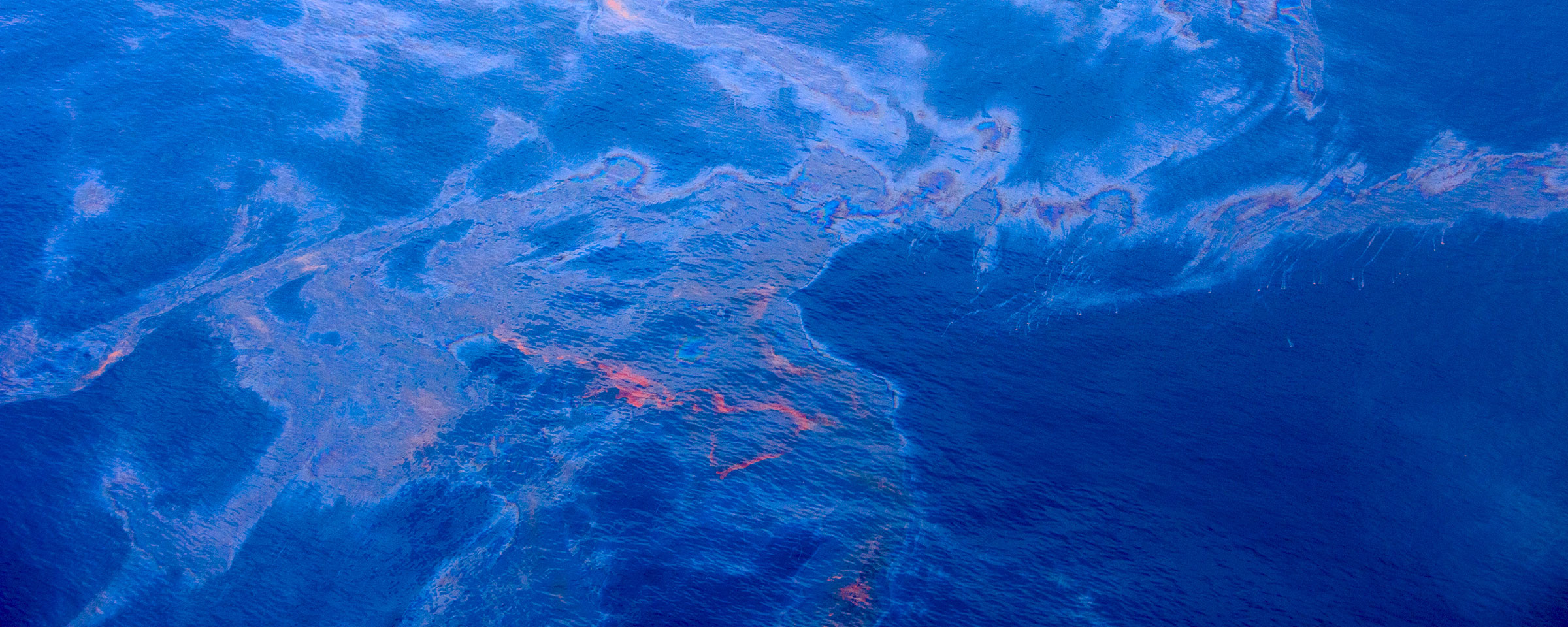 Aerial view of the ocean with distinct discoloration showing the depths of the ocean