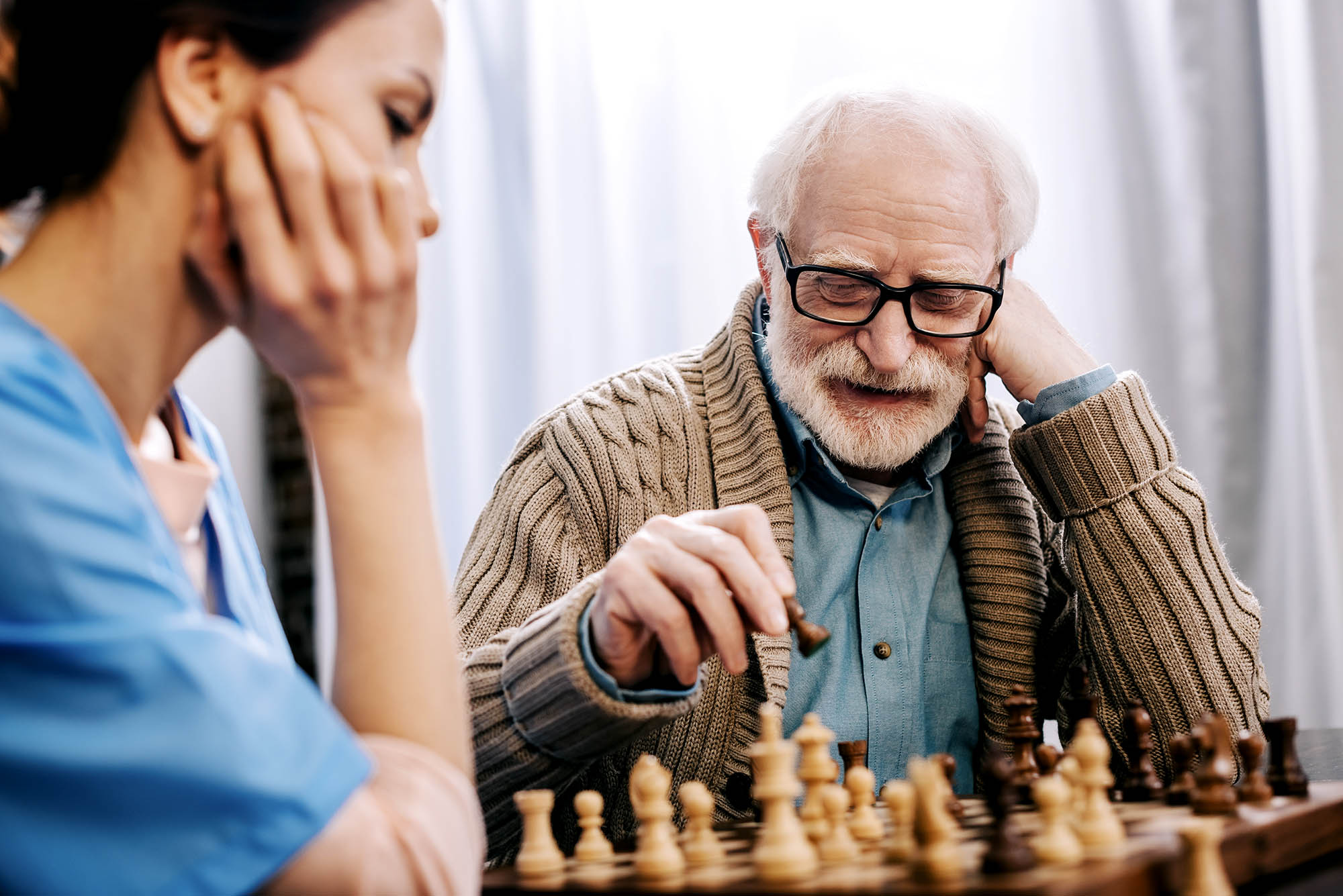 Man playing chess with a healthcare professional