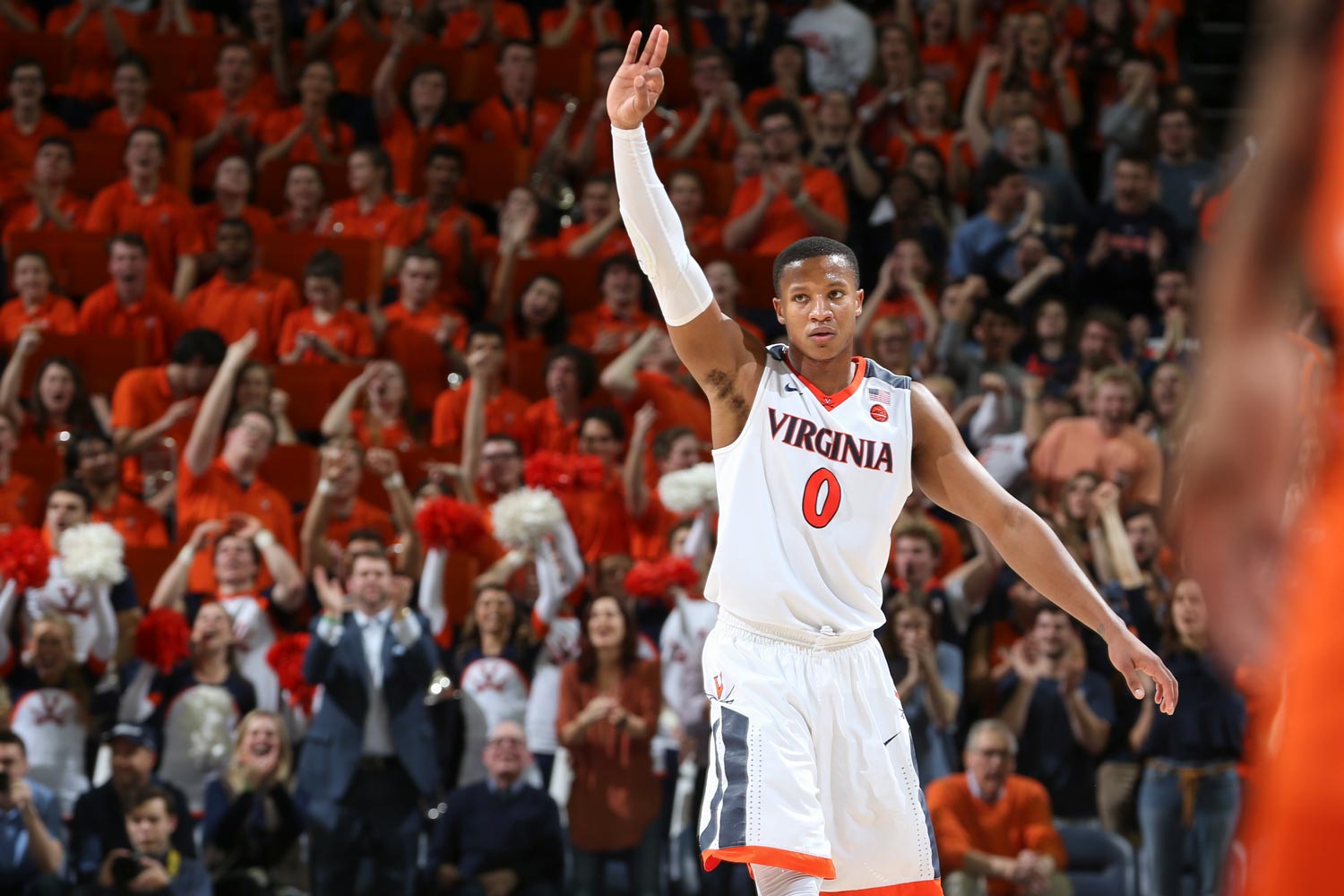 Devon Hall holds up three fingers during a basketball game