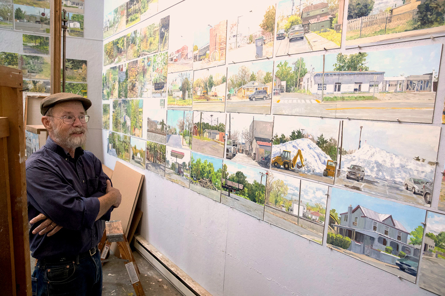 Richard Crozier looking at all of his paintings on the wall