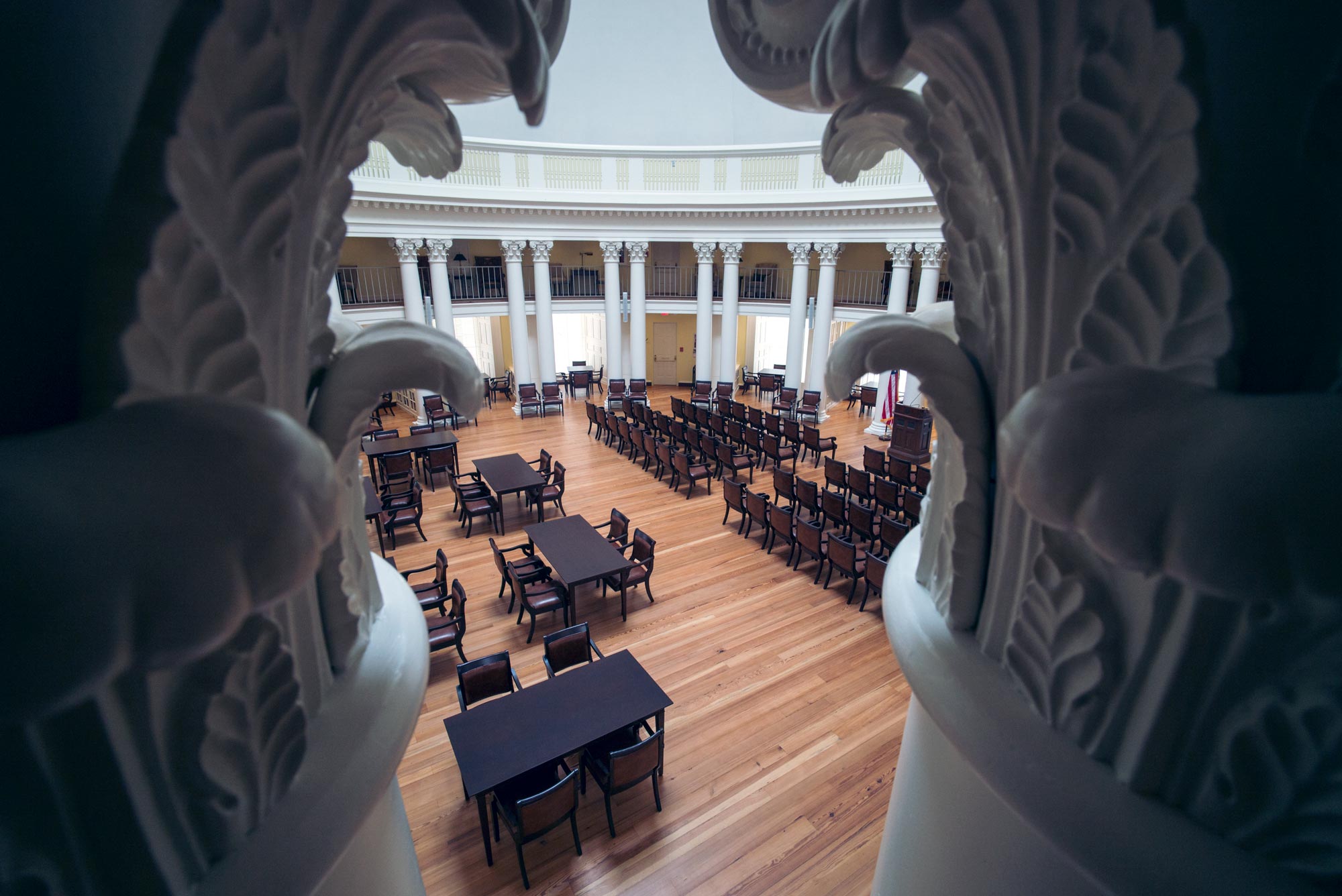 Looking through columns down into the Rotunda floor at tables and chairs set up