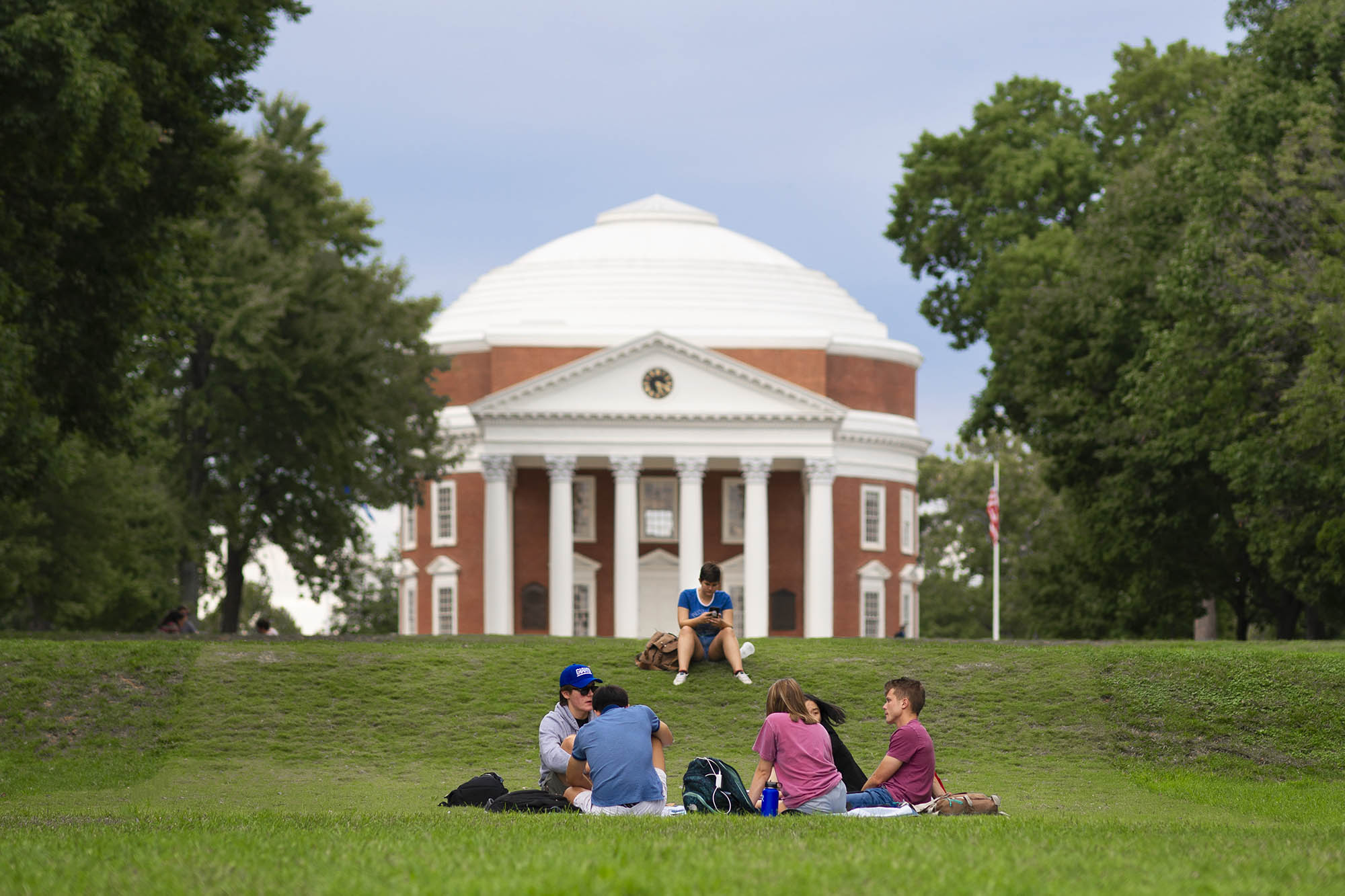 Students sitting on the grass in front of the Rotunda