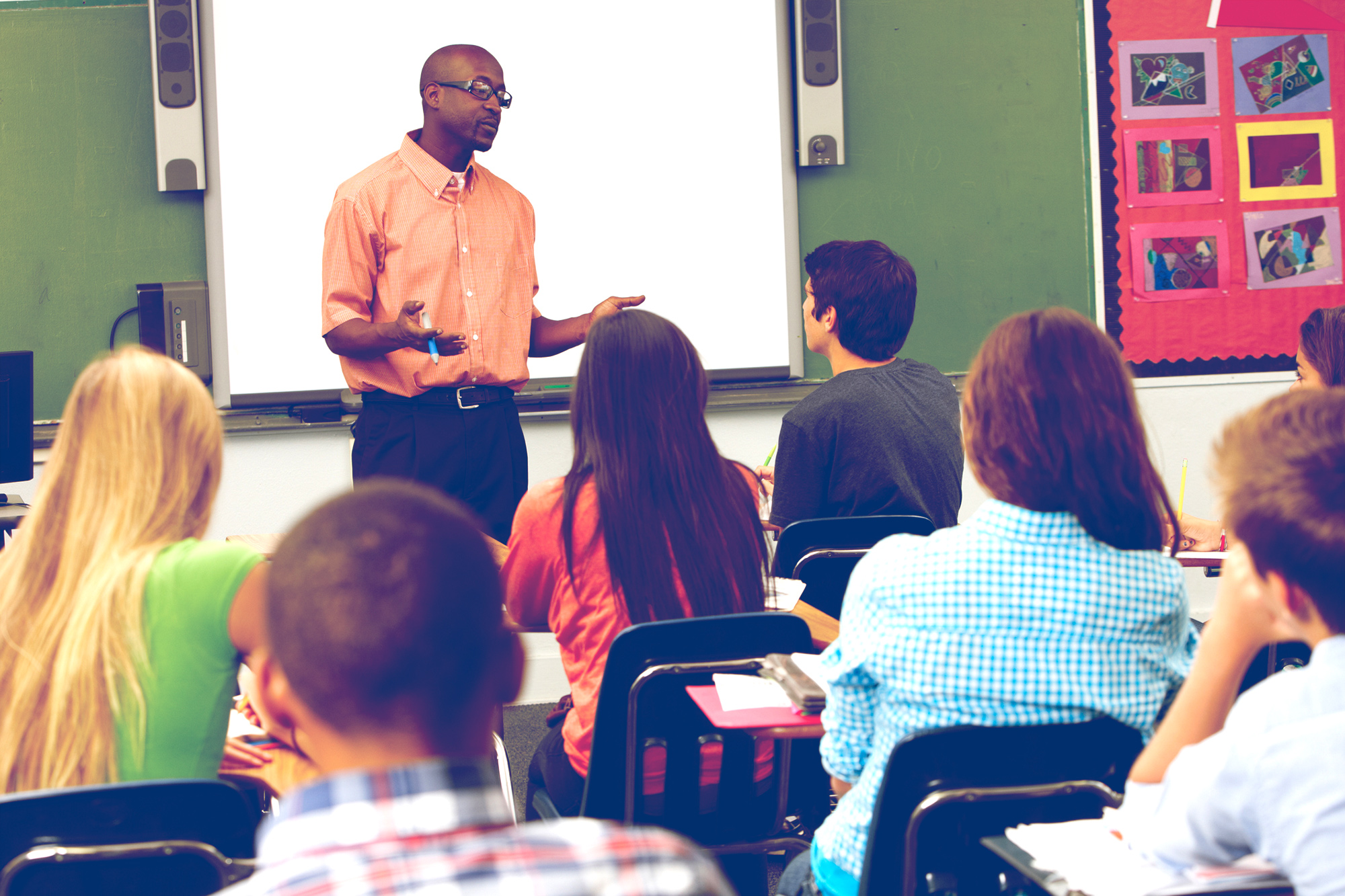 Teacher standing in front of a classroom talking to a high school class