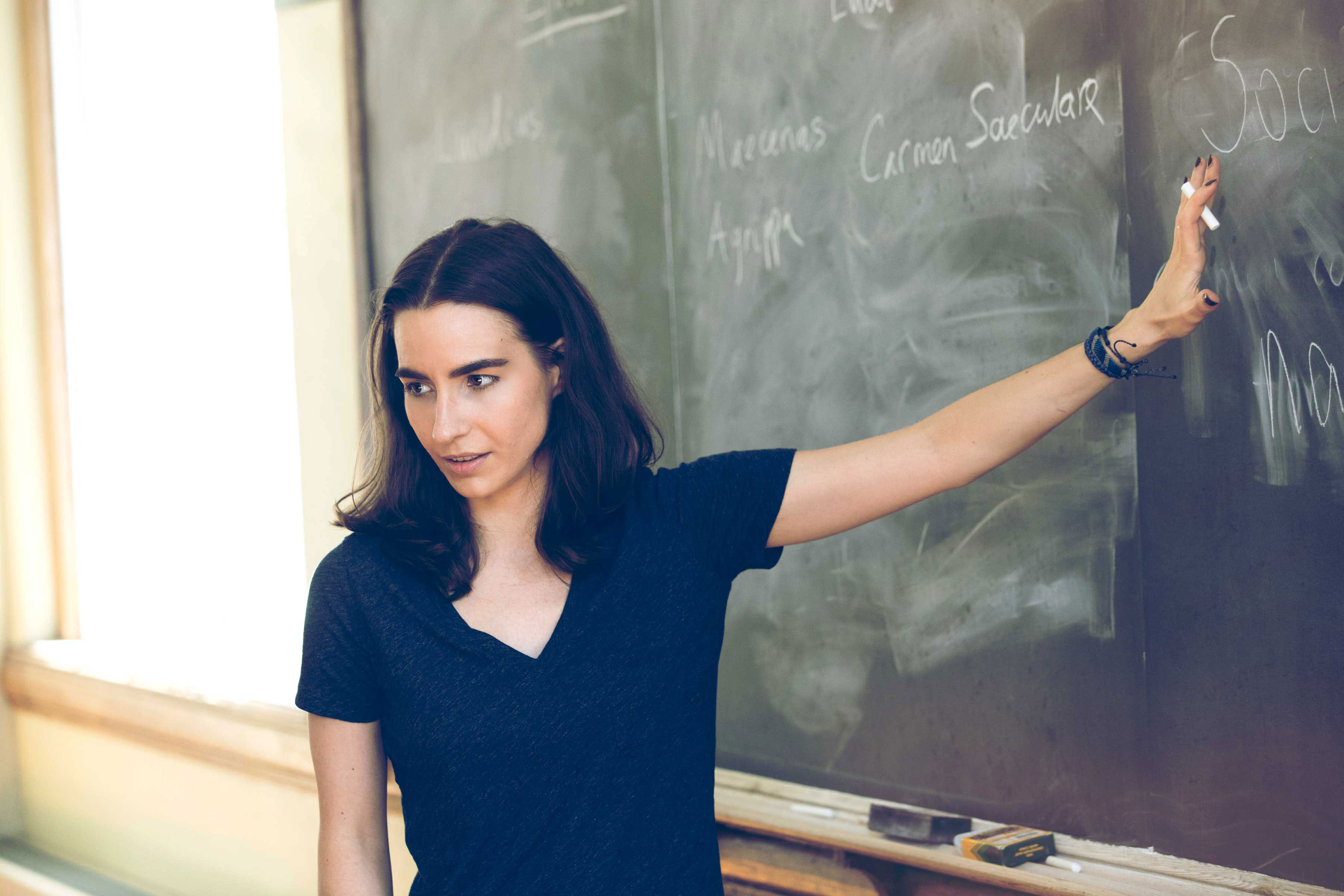 Elizabeth Barnes pointing to something on a chalkboard