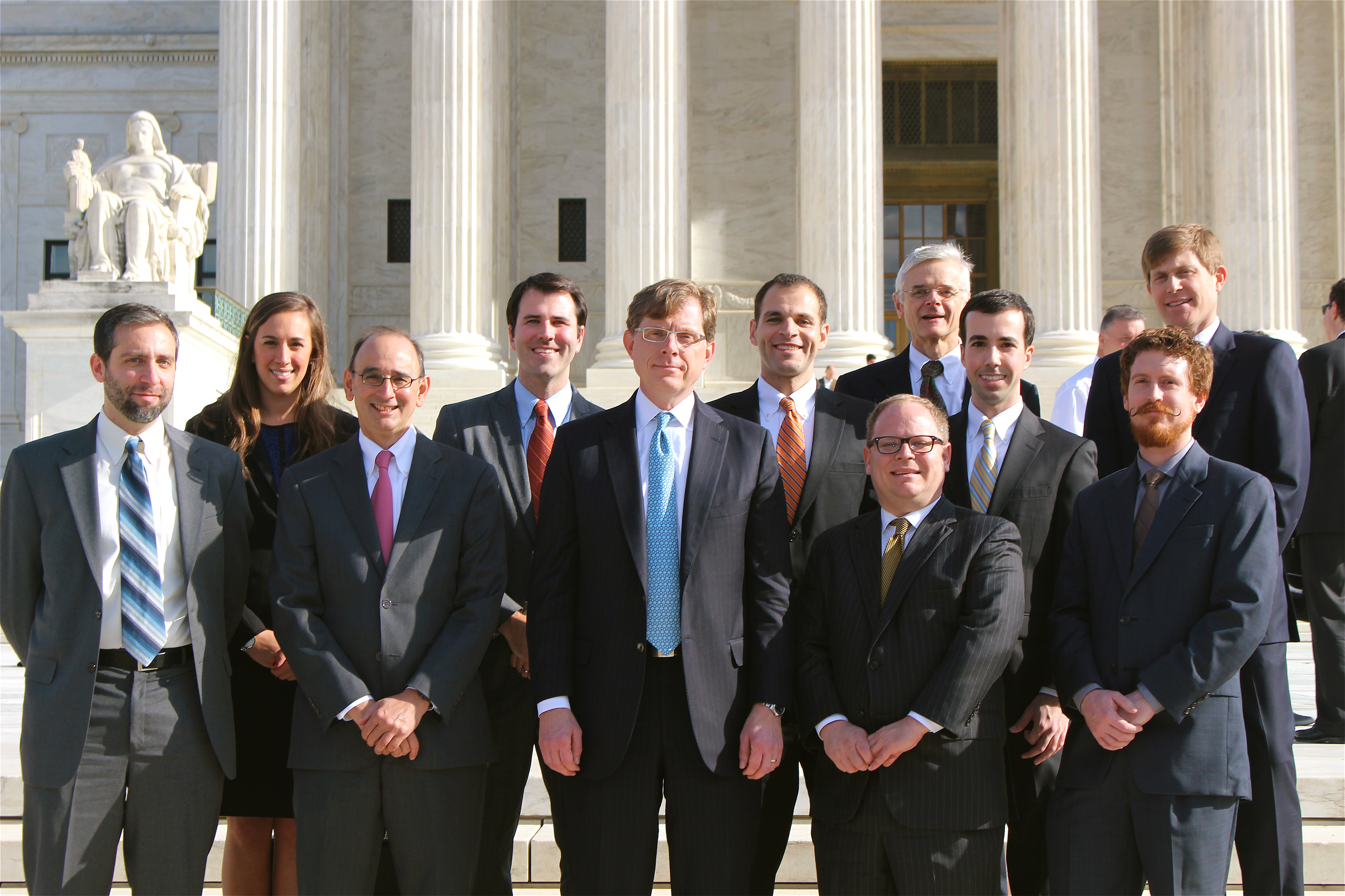 John Elwood (center, in blue tie) stands with a group of lawyers in front of the United States Supreme Court building