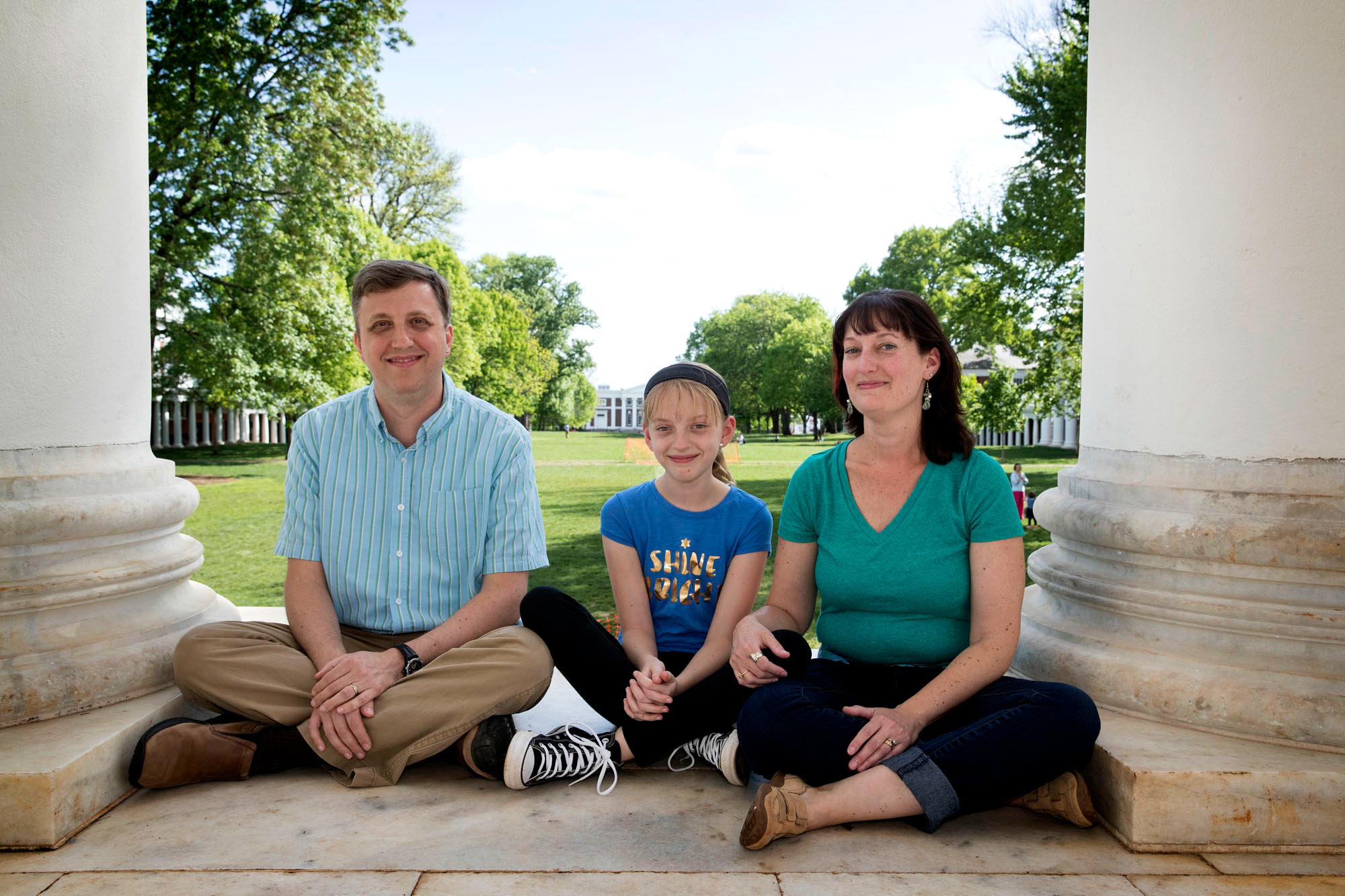Eric Rzeszut,with his daughter Sophie and wife Raya sit between the columns of the Rotunda smiling at the camera