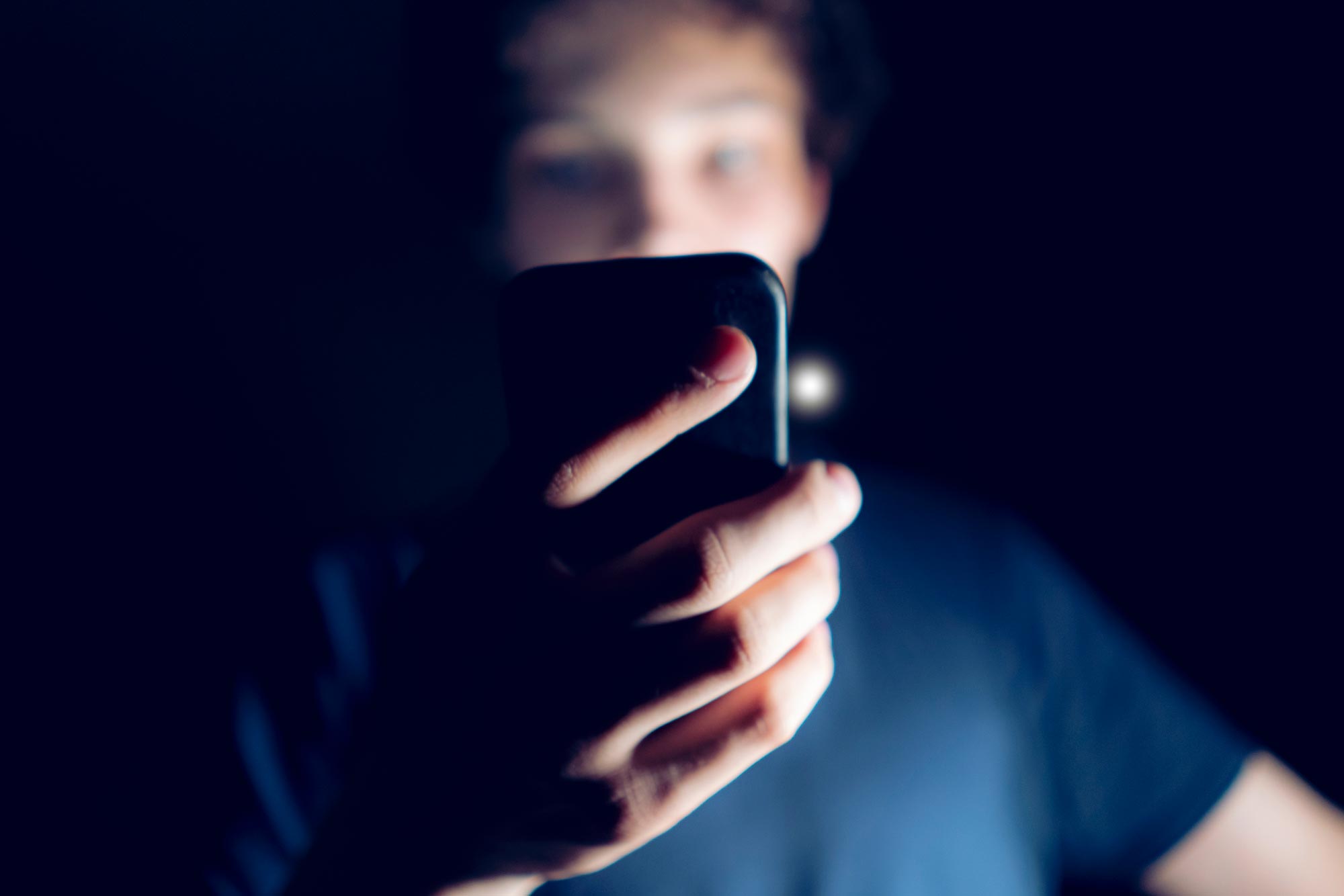Person looking at their phone in the dark