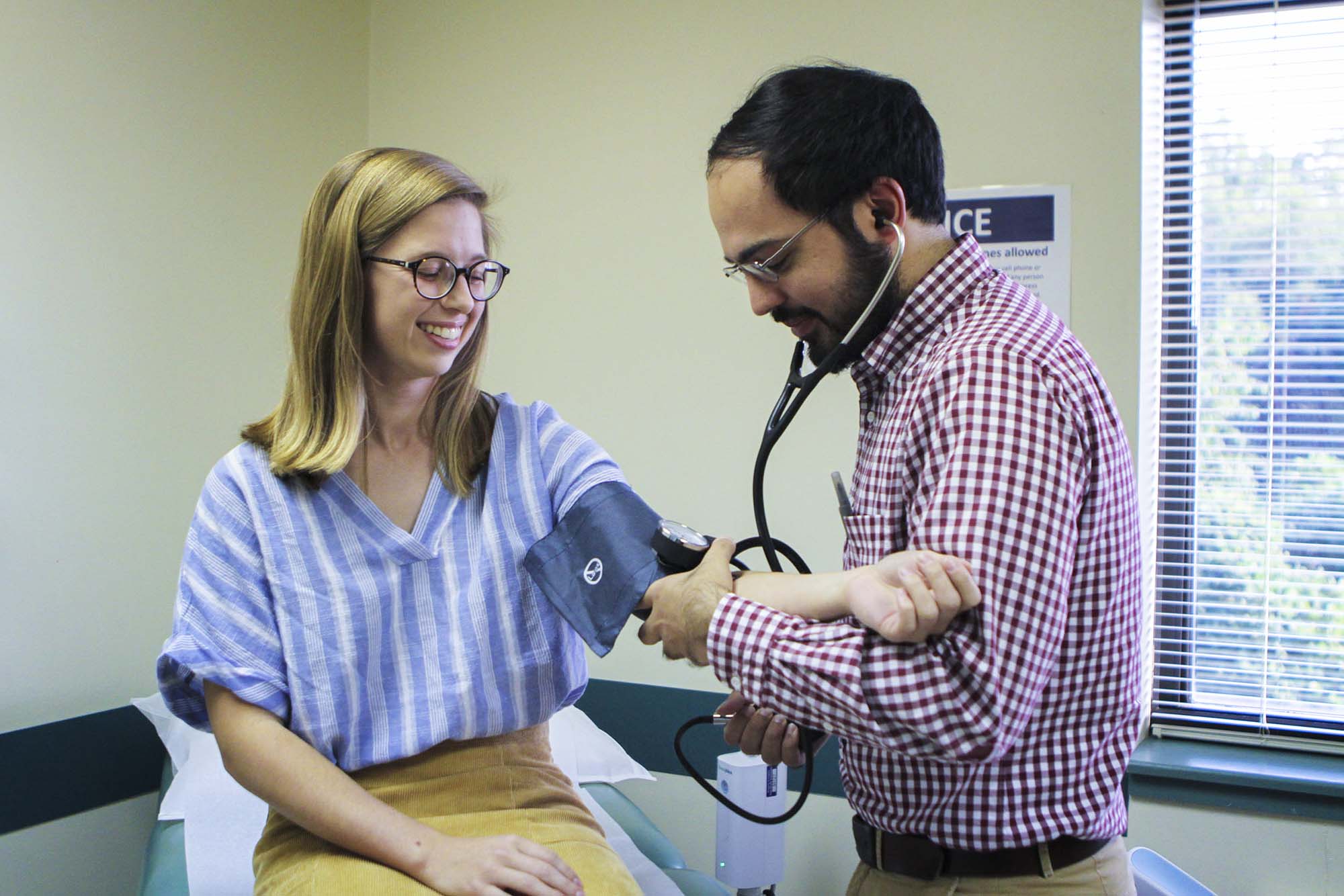 Healthcare professional take the blood pressure of a patient at the free health clinic