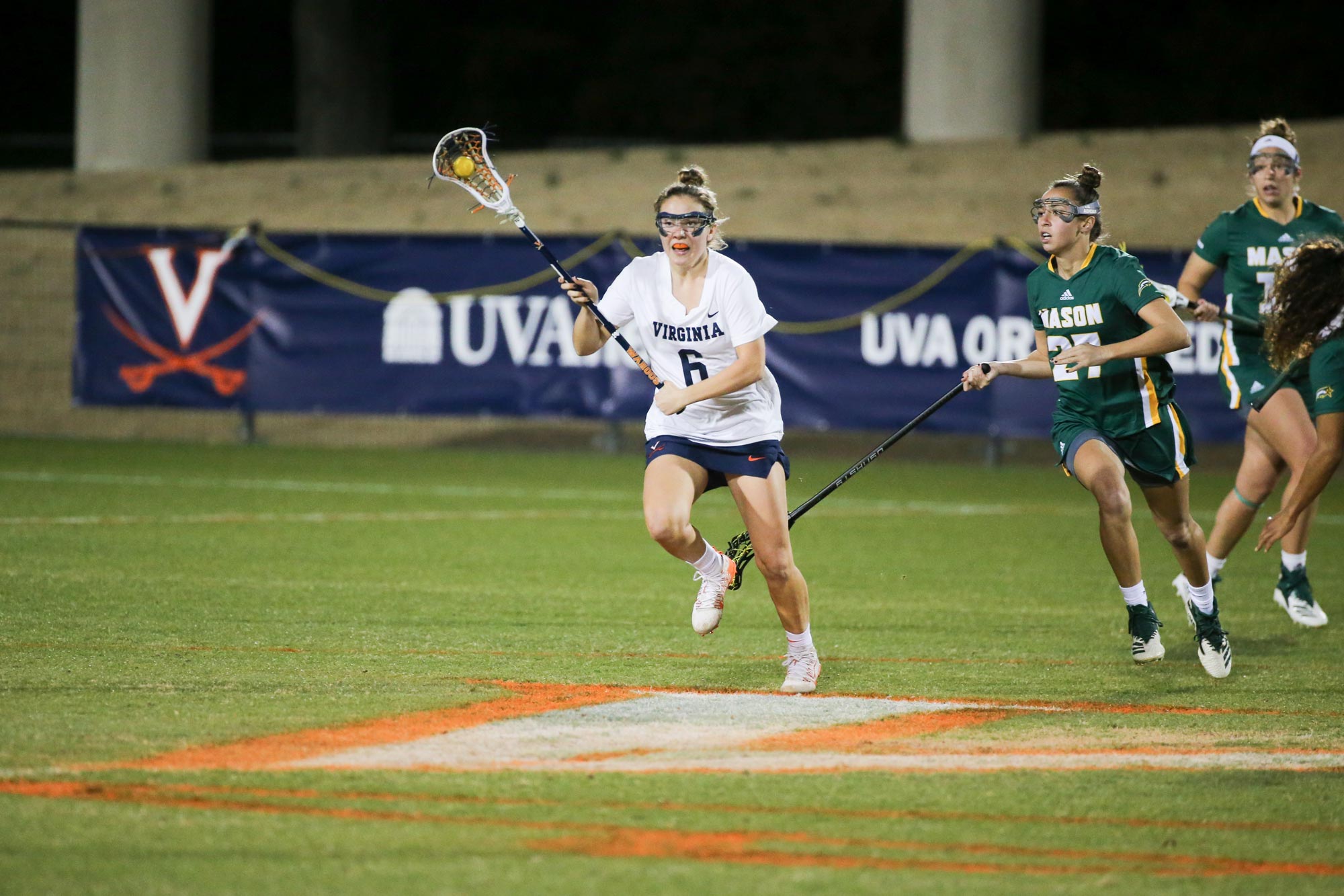 Gwin Sinnott running down the field with the ball during a lacrosse game