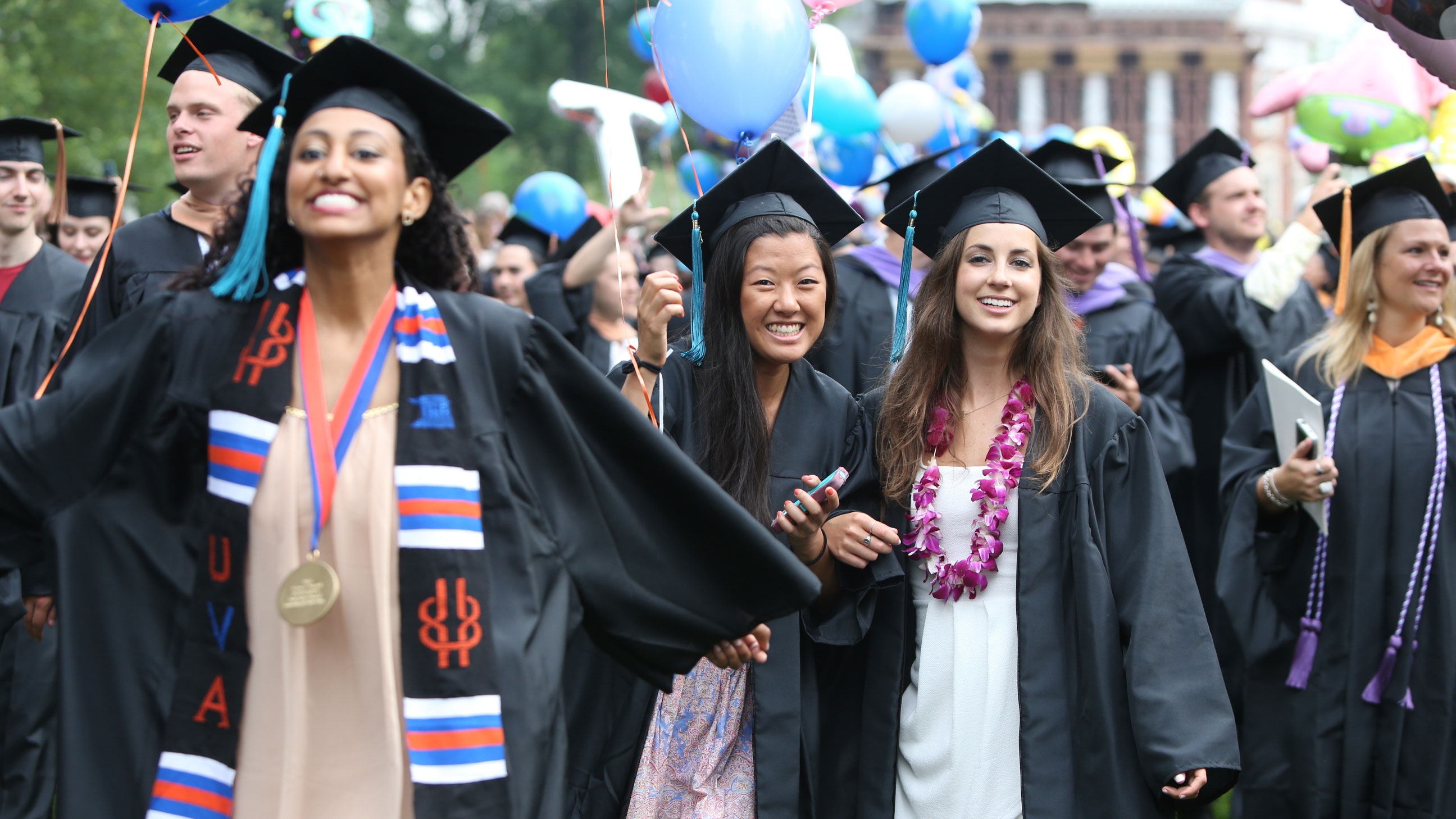 Graduates walking and smiling at the camera