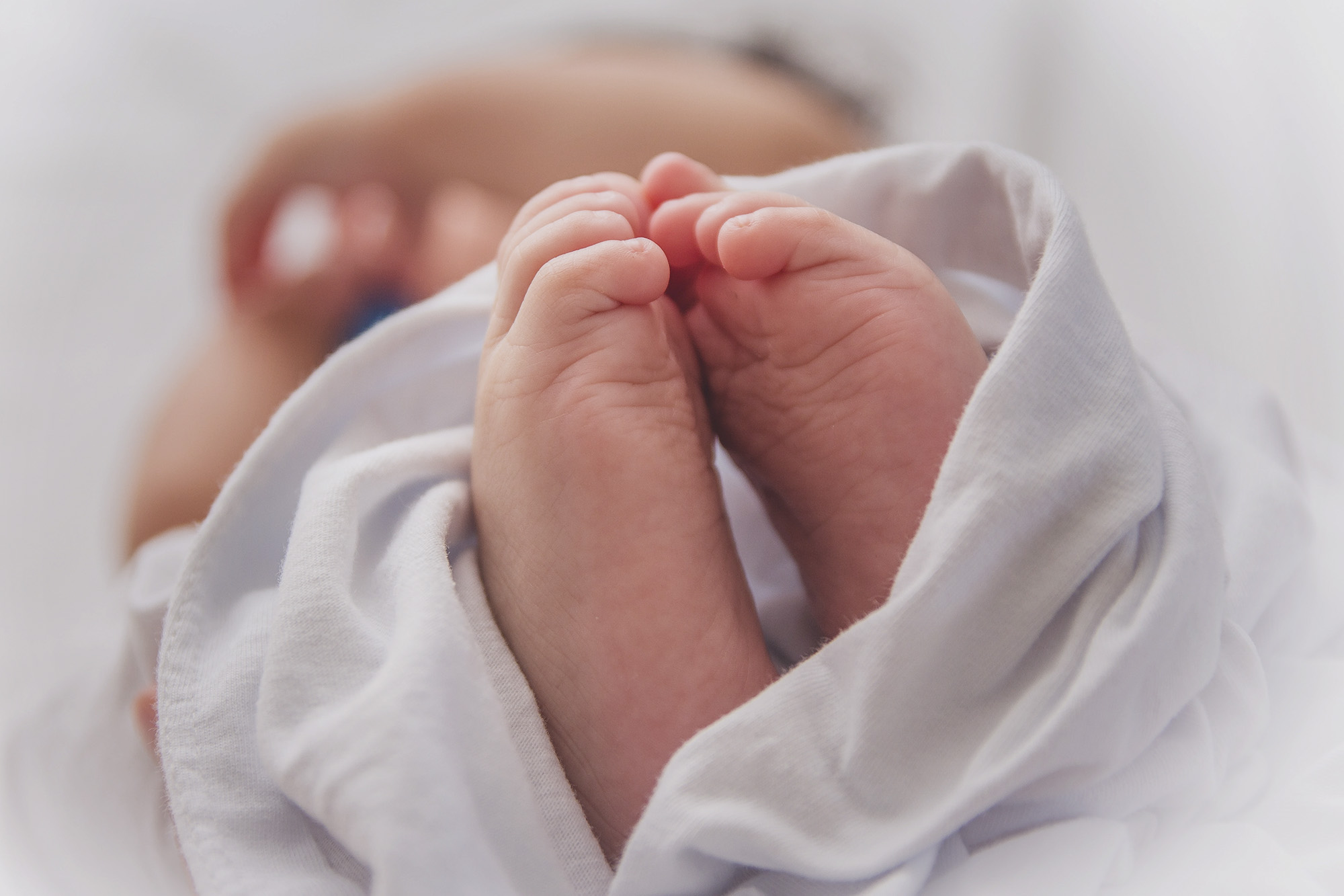 New born baby feet wrapped in a white cloth