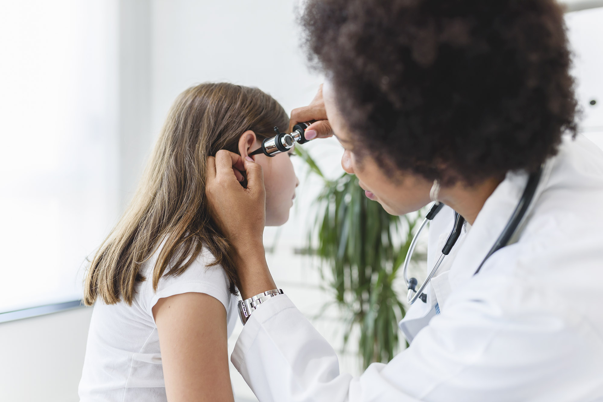 Medical Professional checking the ear of a child