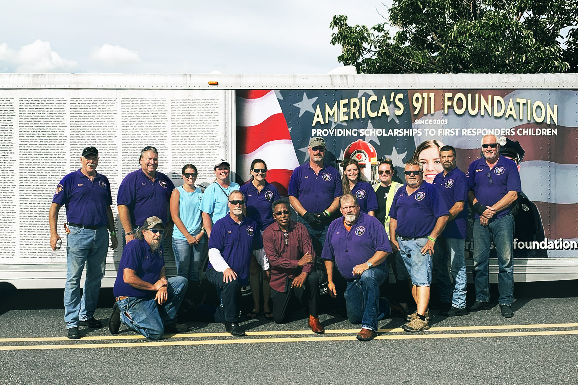 Group photo of people who volunteer for America's 911 Foundation in front of the organizations trailer