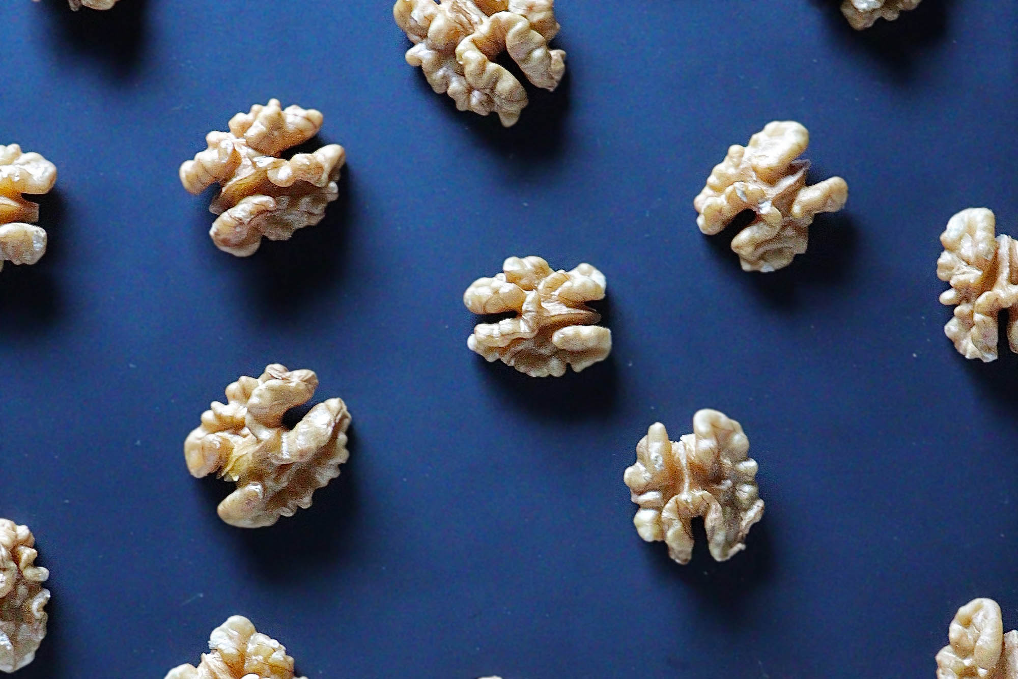 Walnuts spaced out on a dark blue background