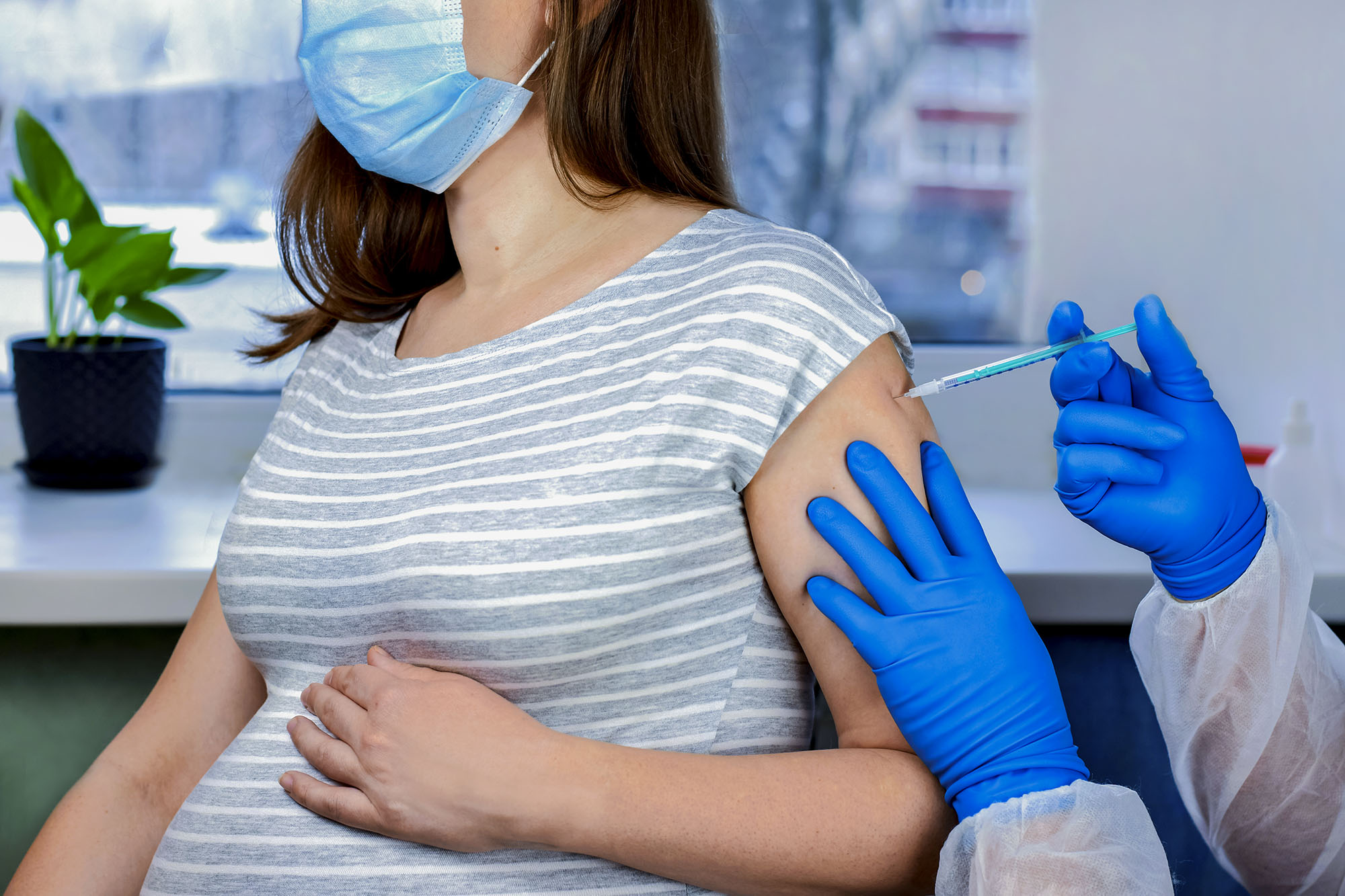 Pregnant Woman receiving her flu vaccine from a healthcare provider