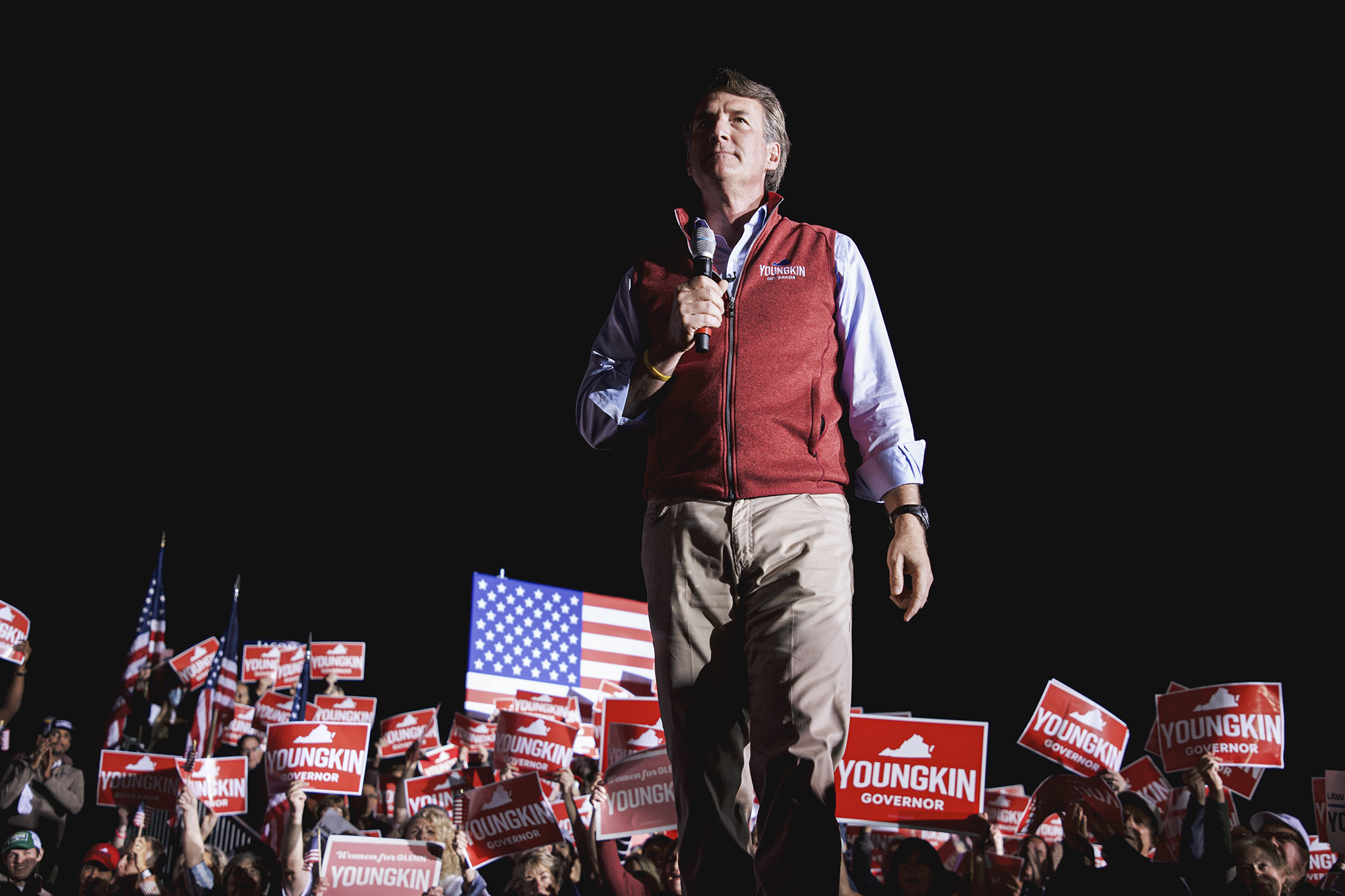 Governor Glenn Youngkin standing at a Rally surrounded by supporters holding red Youngkin for Governor signs