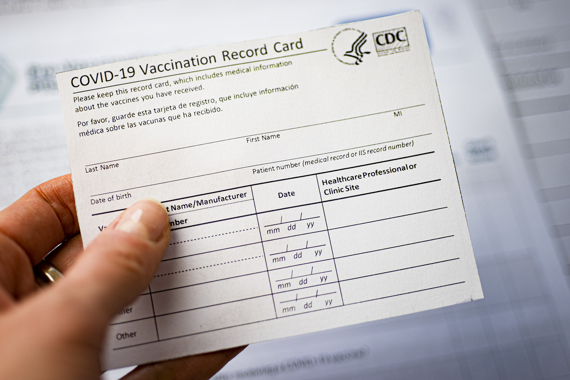 person holding a blank Covid-19 Vaccination Record Card