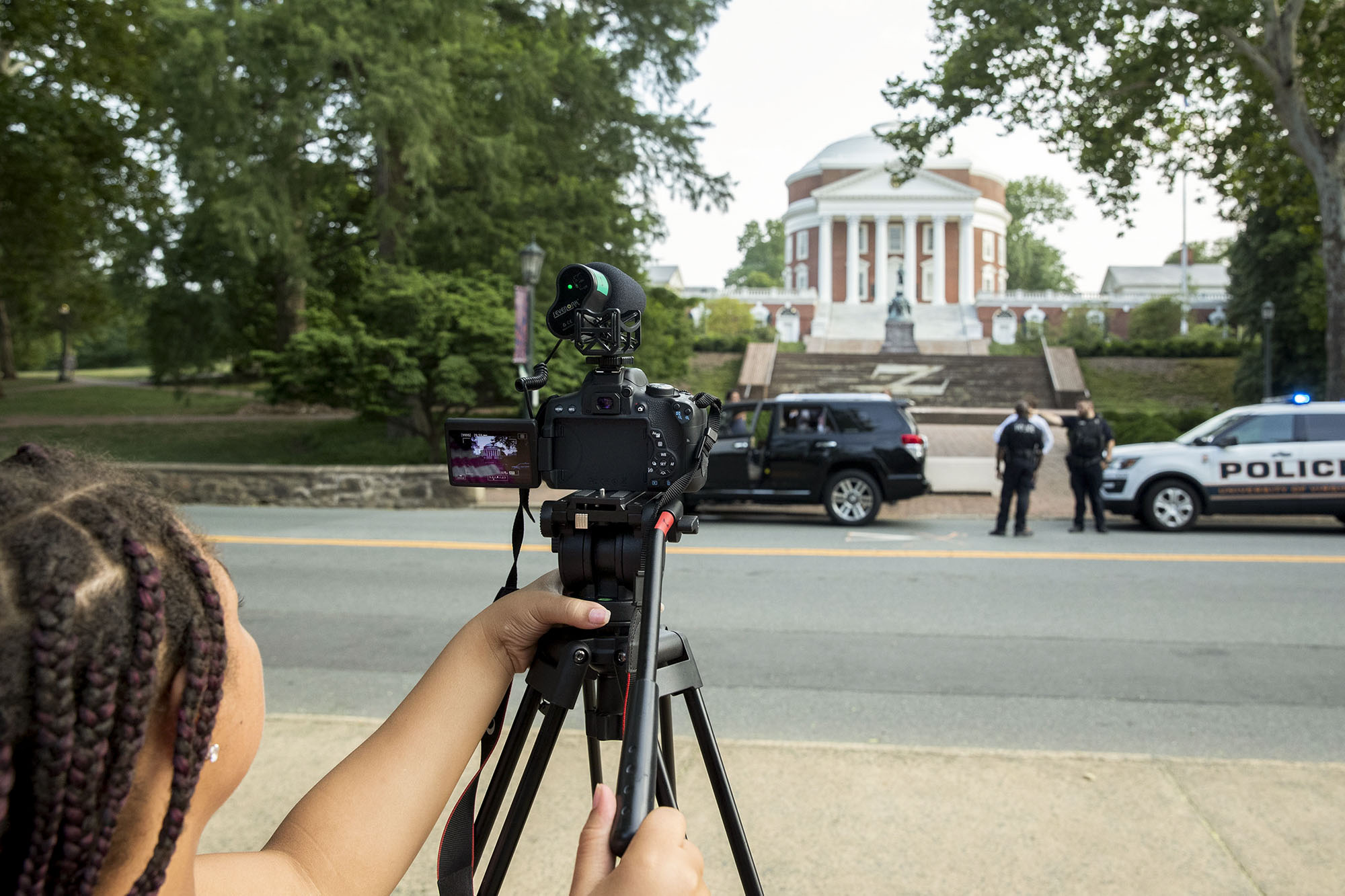 Student recording a staged traffic stop in front of the Rotunda
